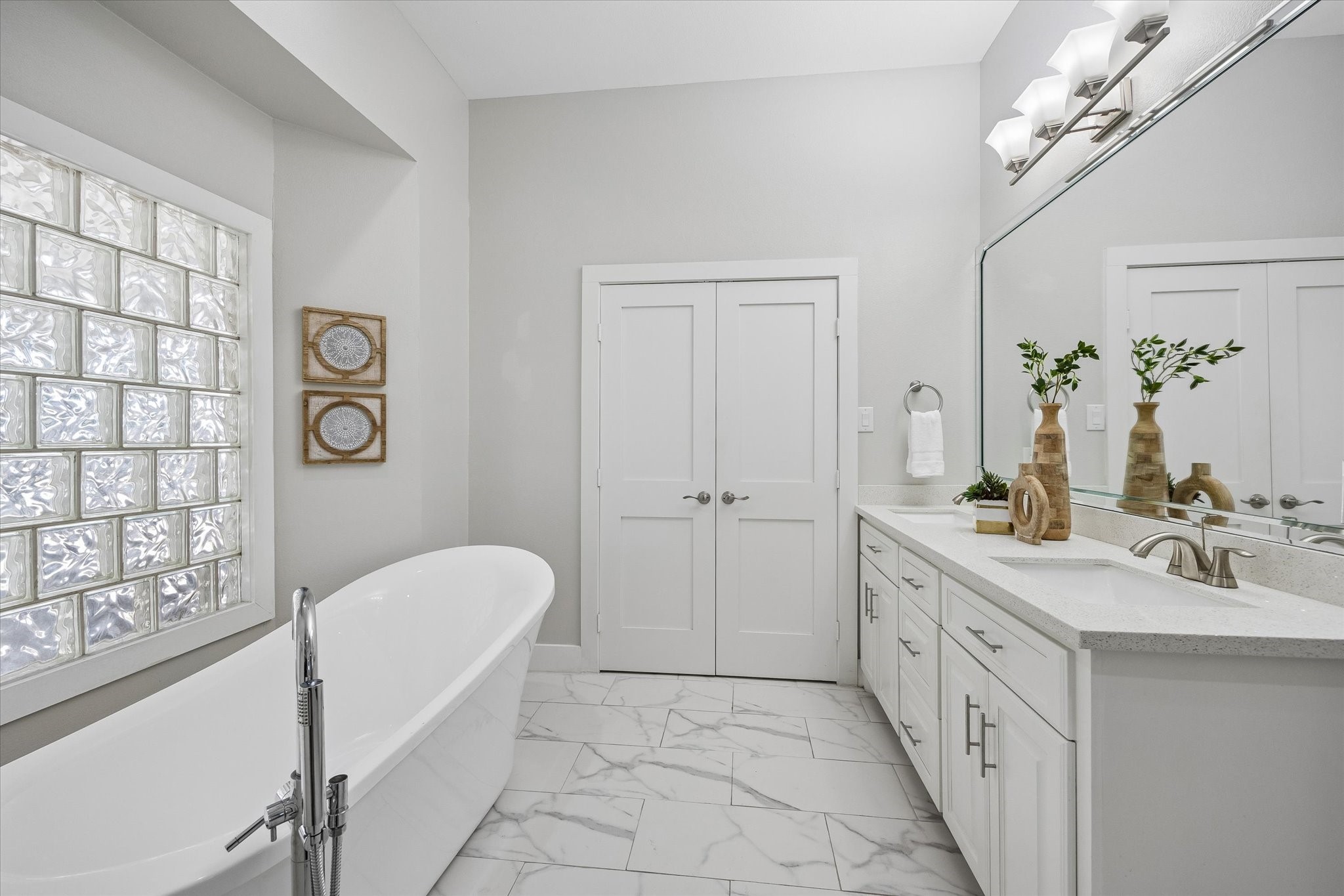 Enjoy a daily dose of luxury in this spa-like ensuite, where a freestanding soaking tub, walk-in shower, long dual sink vanity and soft neutral finishes create a calm, polished feel. Abundant storage keeps everything neatly tucked away, making this beautiful retreat as practical as it is relaxing.