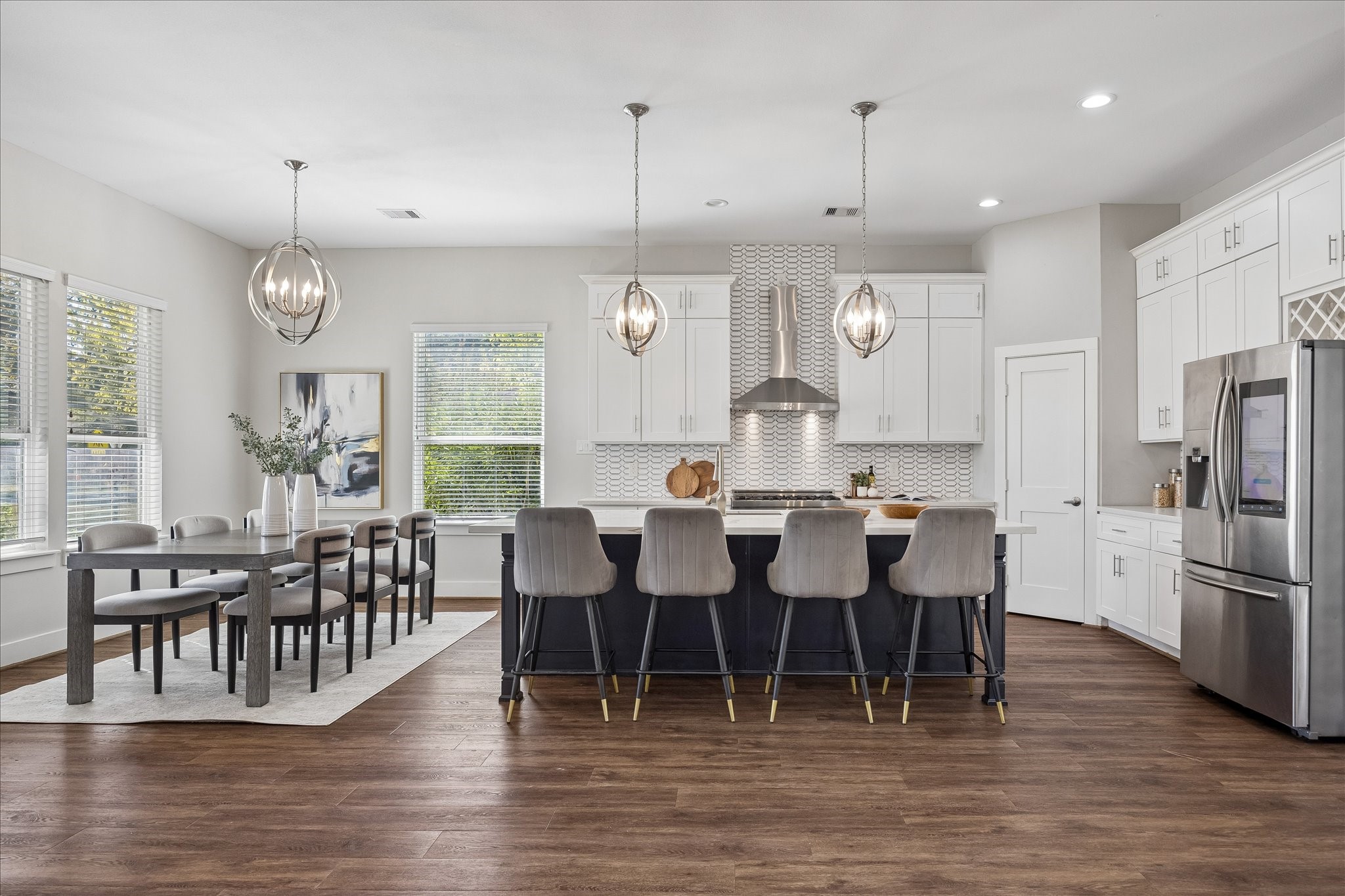 With plenty of room to cook, dine and entertain, this kitchen makes everyday meals and lively gatherings a little more fun! Sleek tile backsplash, stainless steel appliances, contrasting island with bar seating and oversized pantry add style and convenience, with ample room for the sous chef and cleanup crew, too.