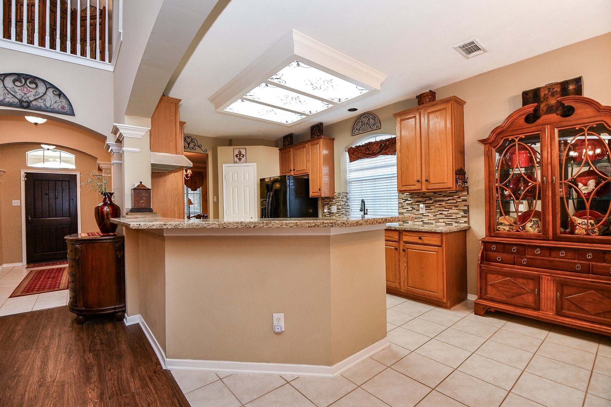 Whether it's a quick breakfast before heading out the door or a casual spot for guests to gather while dinner is being prepared, the extended granite breakfast bar adds another layer of functionality to this inviting kitchen.