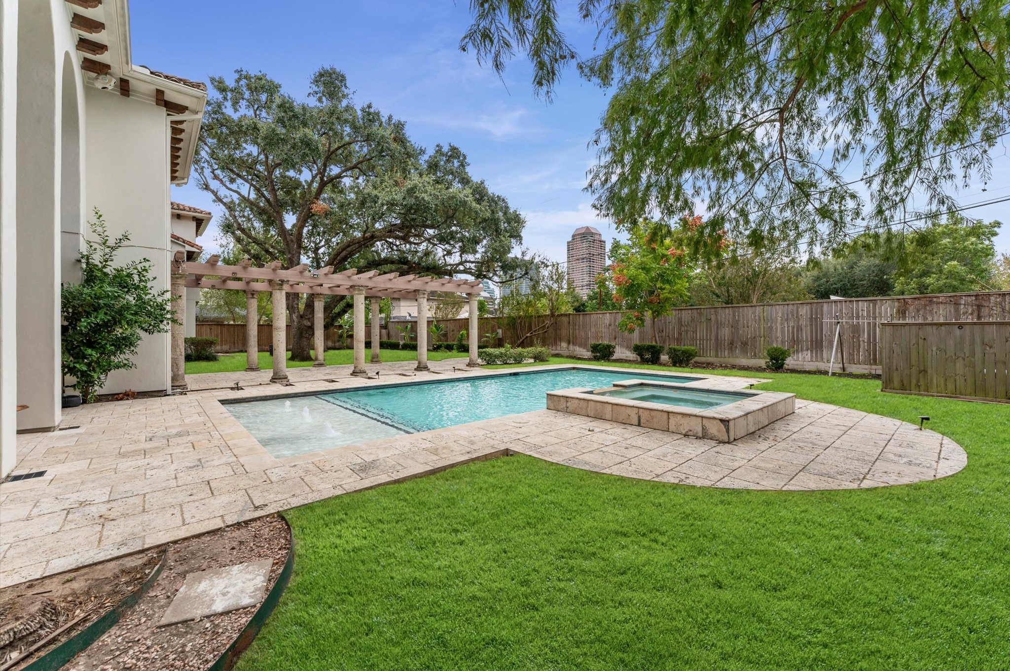 The rear elevation showcases the estate's exceptional outdoor living amenities, including the covered loggia, open-air patios, expansive pergola, saline pool and raised spa, and elevated side deck.