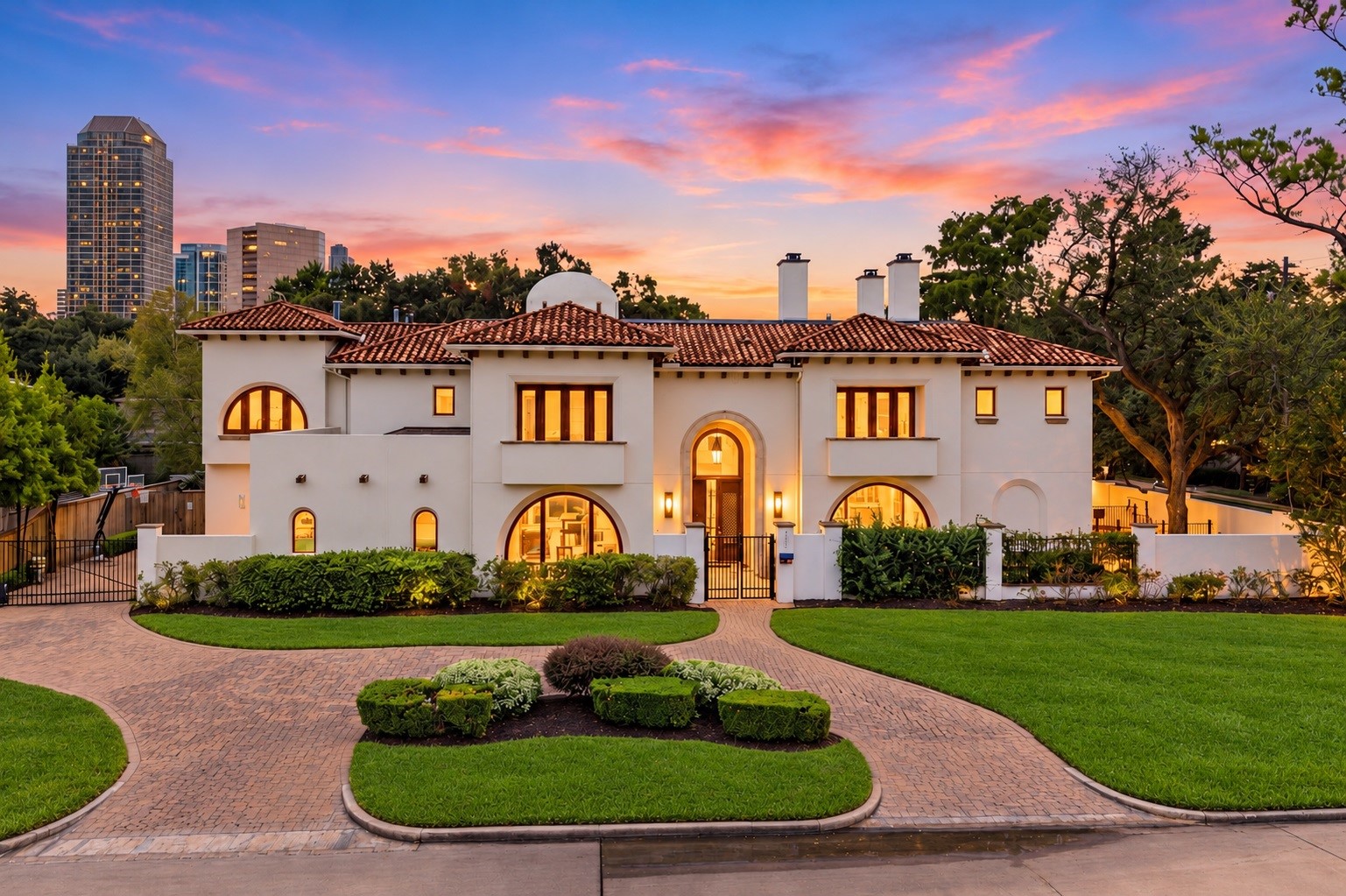 Designed by Robert Dame, this exceptional estate showcases the timeless elegance of Modern Spanish architecture, with clean lines, a Portuguese tile roof, expansive arched picture windows, and a commanding presence on a private half-acre-plus corner lot.
