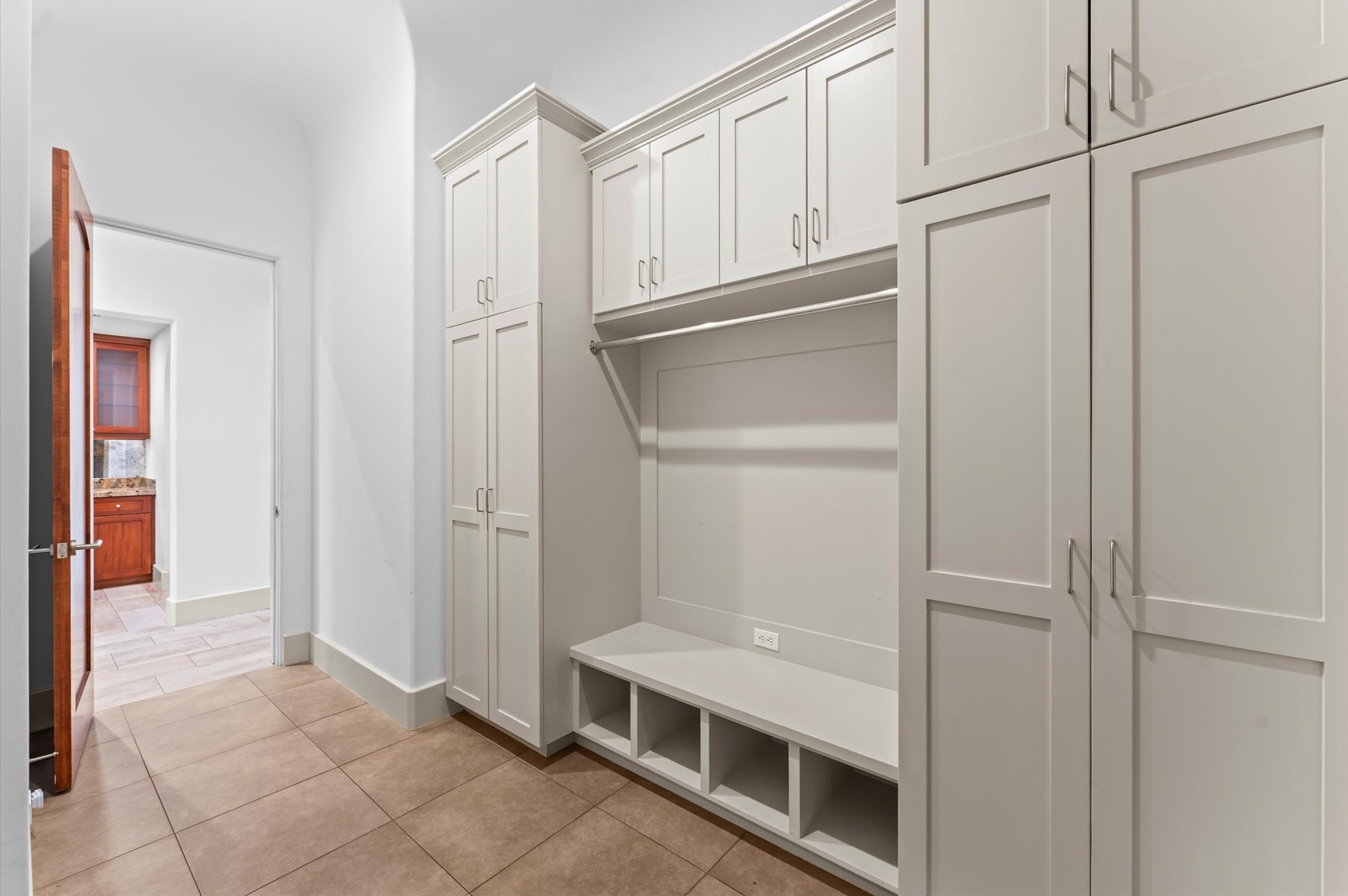 An oversized mudroom featuring custom built-in shelving and abundant storage, designed to keep everyday essentials organized while maintaining a seamless flow throughout the home.