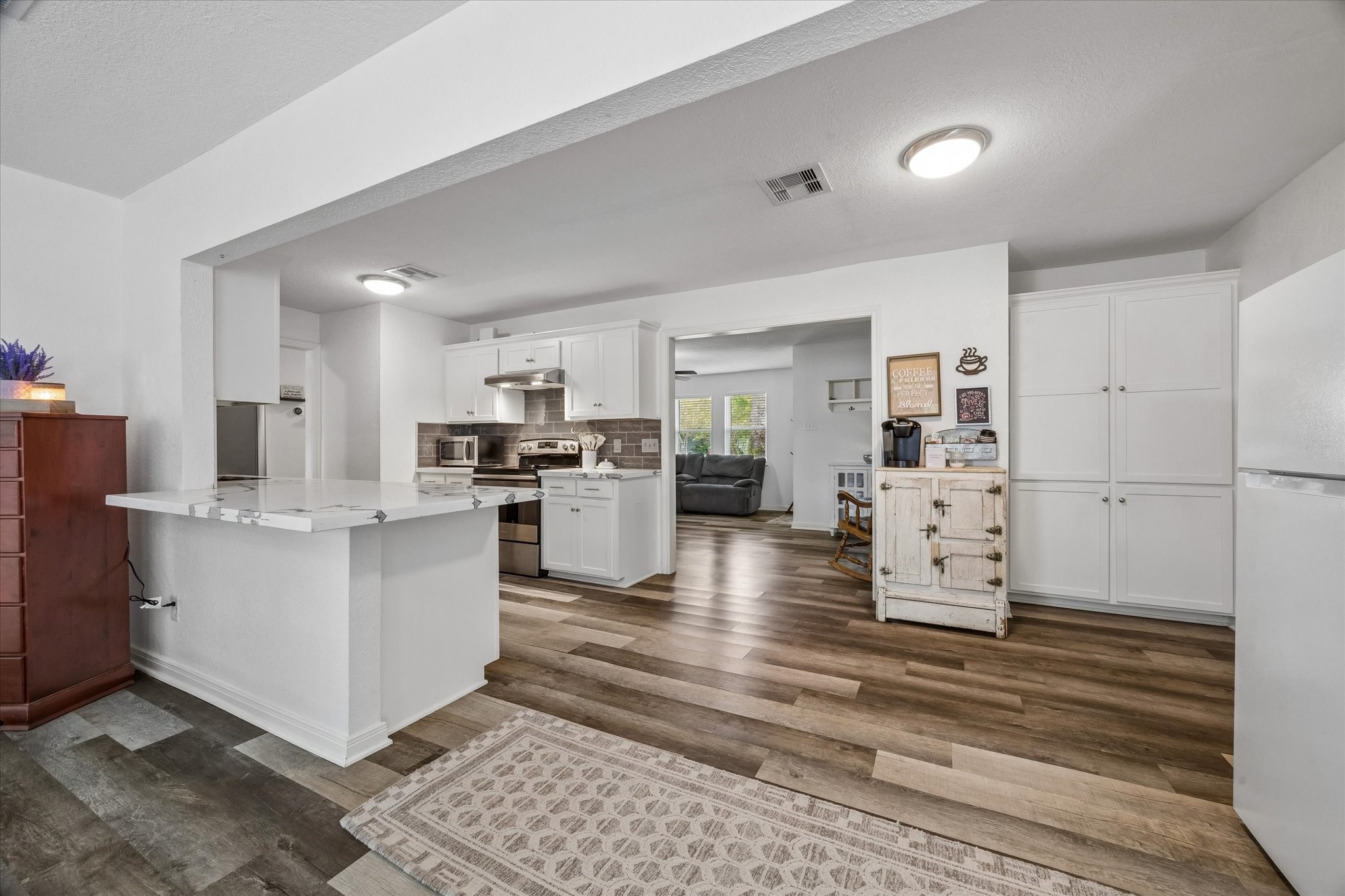 The utility room is located to the right of the pantry cabinets.