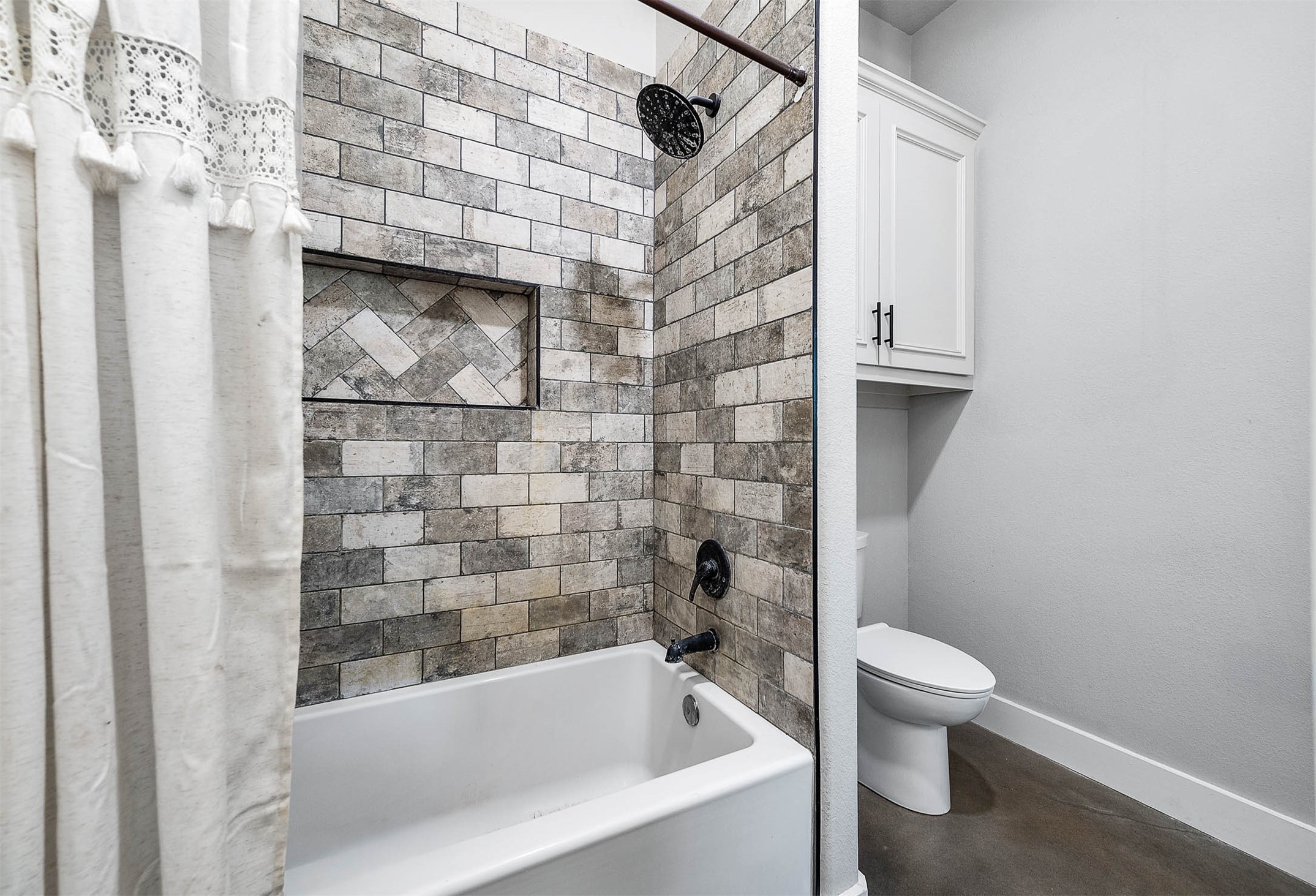 Full bathroom with tub and shower combination and tile surround. This photo may be edited using AI tools.