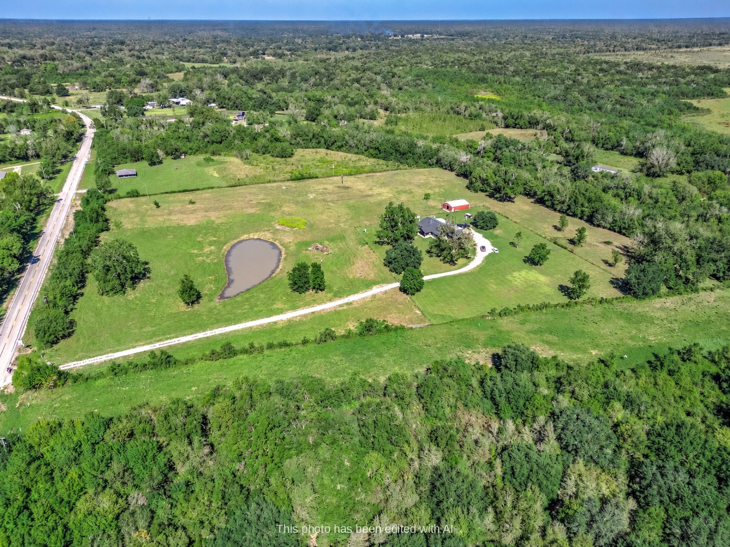 Aerial view of the 15.9-acre Sweeny property showing the pond, pasture, home and gravel drive off FM 524. This photo may be edited using AI tools.