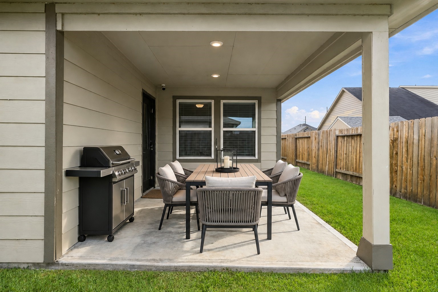 This inviting photo captures a warm and welcoming covered back patio, perfect for relaxing or gathering with family and friends. The patio offers a comfortable, shaded retreat that bridges indoor and outdoor living.