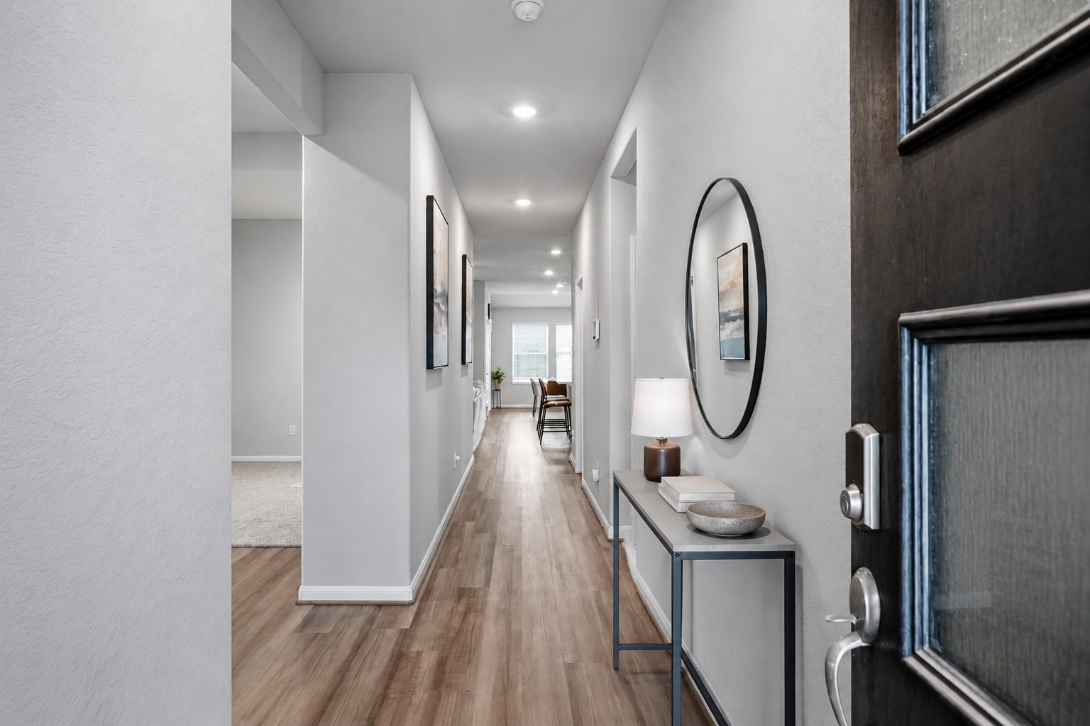 Virtually Staged: This inviting entryway features a long, open hallway with soft neutral walls, elegant wood-look flooring, and recessed ceiling lighting that creates a bright, welcoming atmosphere. Virtually Staged: This inviting entryway features a long, open hallway with soft neutral walls, elegant wood-look flooring, and recessed ceiling lighting that creates a bright, welcoming atmosphere.
