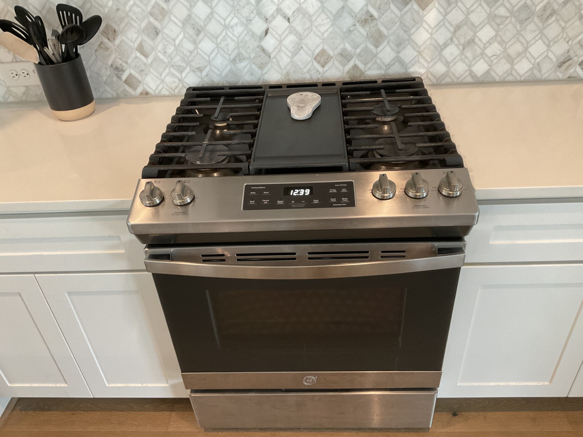 Gas range with a griddle cooktop. 5 burners.