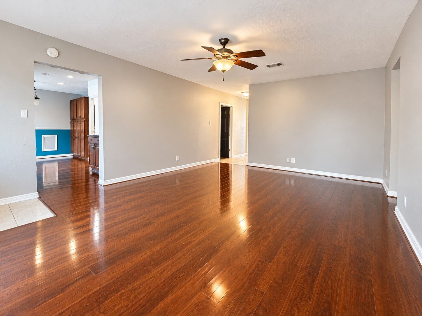 Living area has ceiling fan and wood flooring