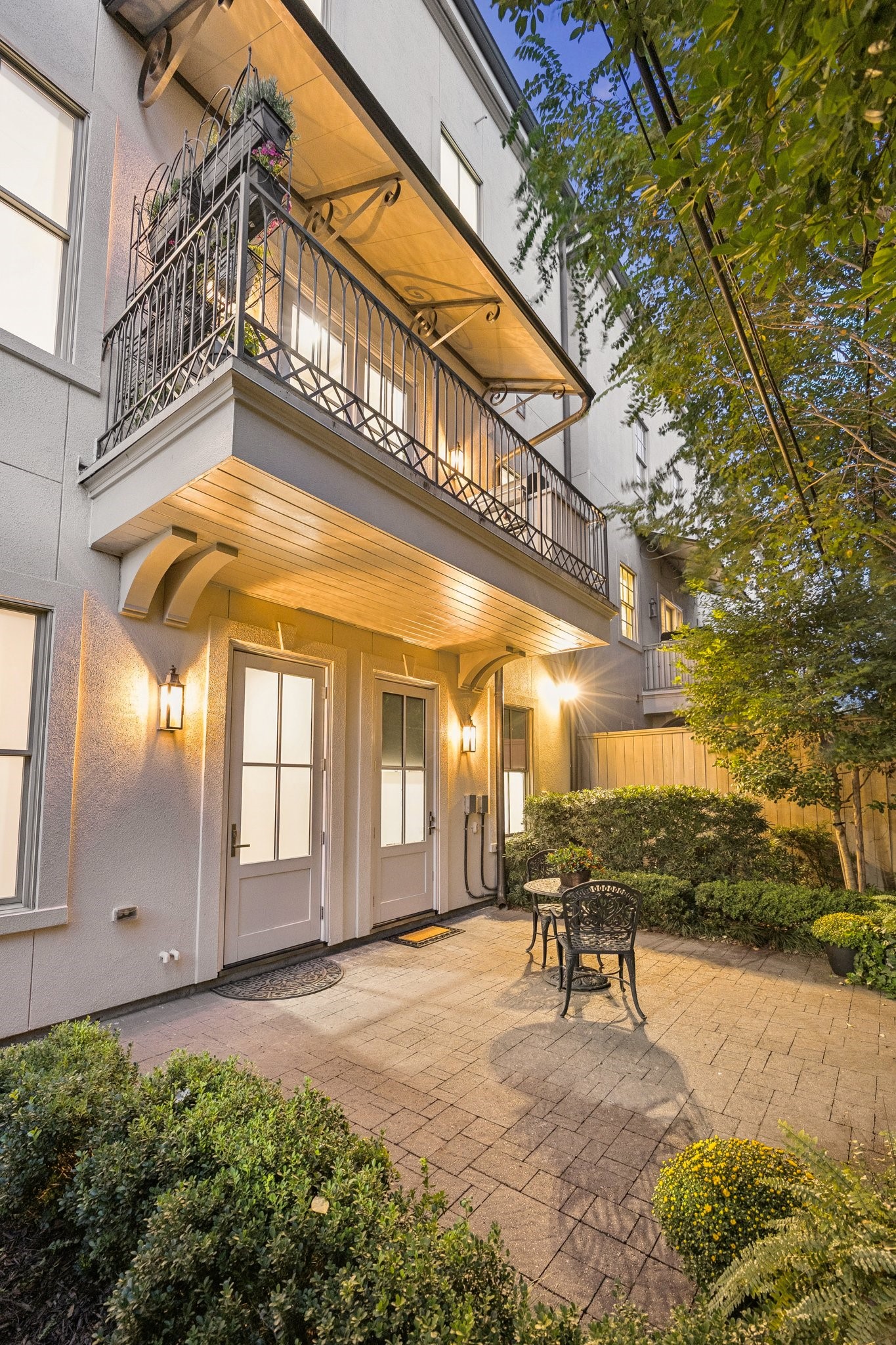Cozy, private backyard patio surrounded by lush landscaping, offering a charming outdoor retreat.
