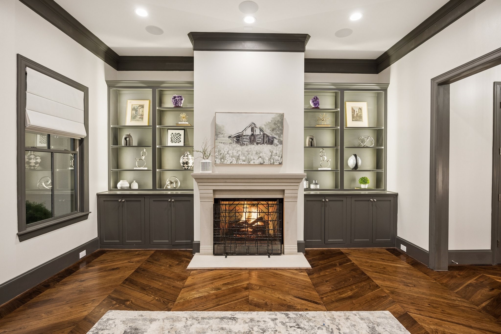 Elegant gas fireplace framed by custom built-in cabinetry with dimmable shelf lighting, creating a warm, sophisticated ambiance and a beautiful focal point for the formal living room.