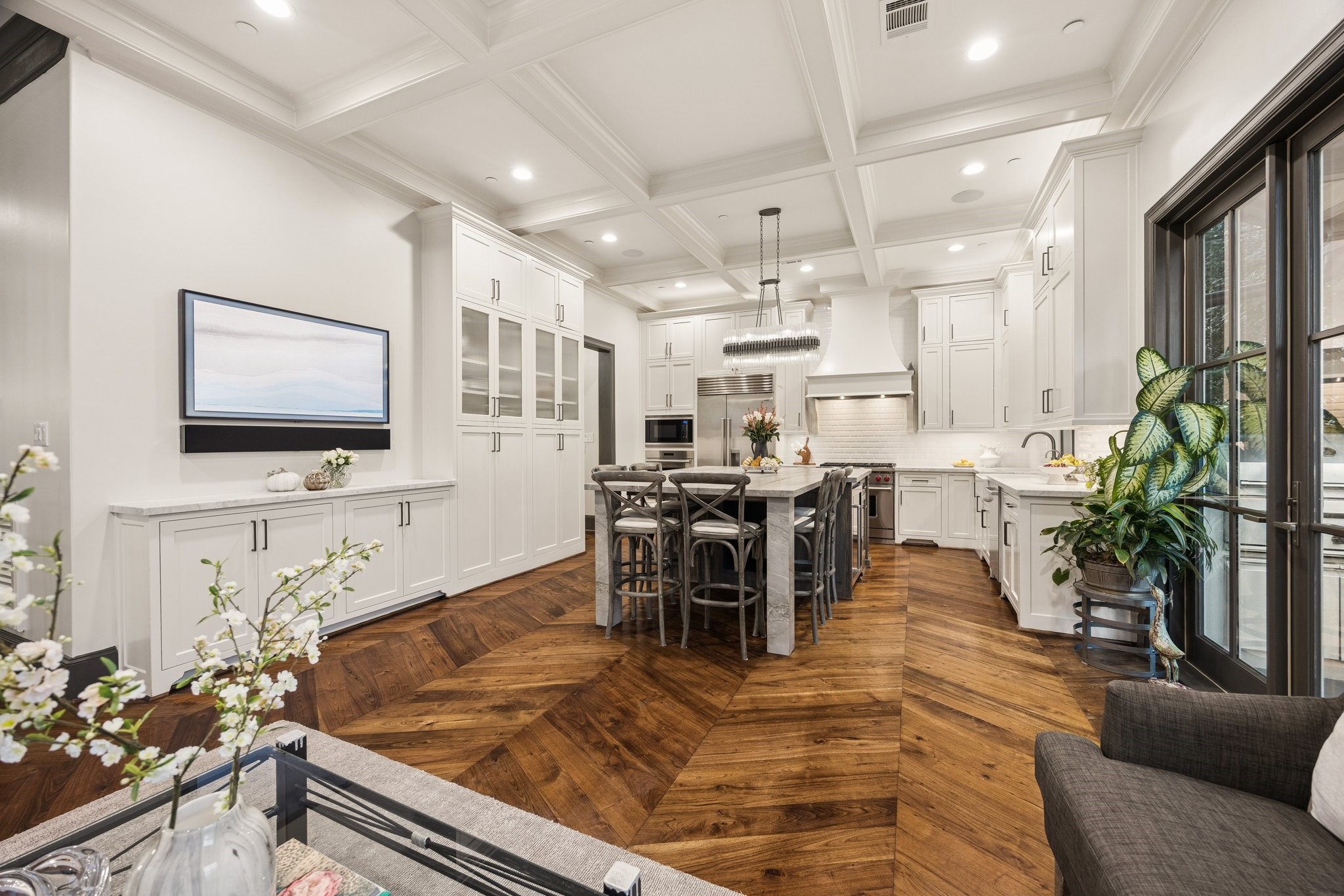 Beautifully designed living space with custom built-in cabinetry and a perfect wall for a large-screen TV, creating an ideal setting for entertainment while maintaining an elegant, open connection to the kitchen.