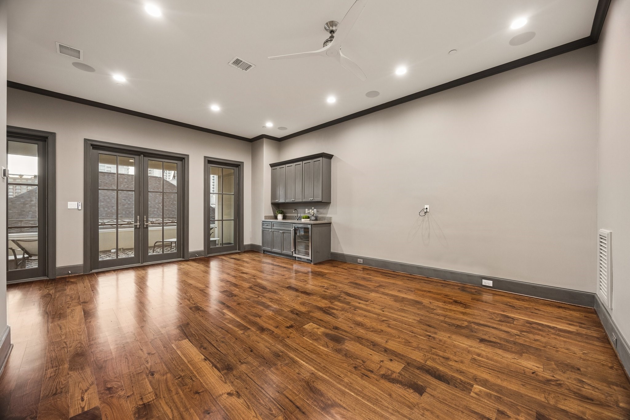 Expansive, light-filled fourth-floor game room with a built-in beverage station, full bathroom with walk-in shower, and access to a spacious private terrace with Houston skyline views. Ideal as an entertainment retreat or private guest suite.