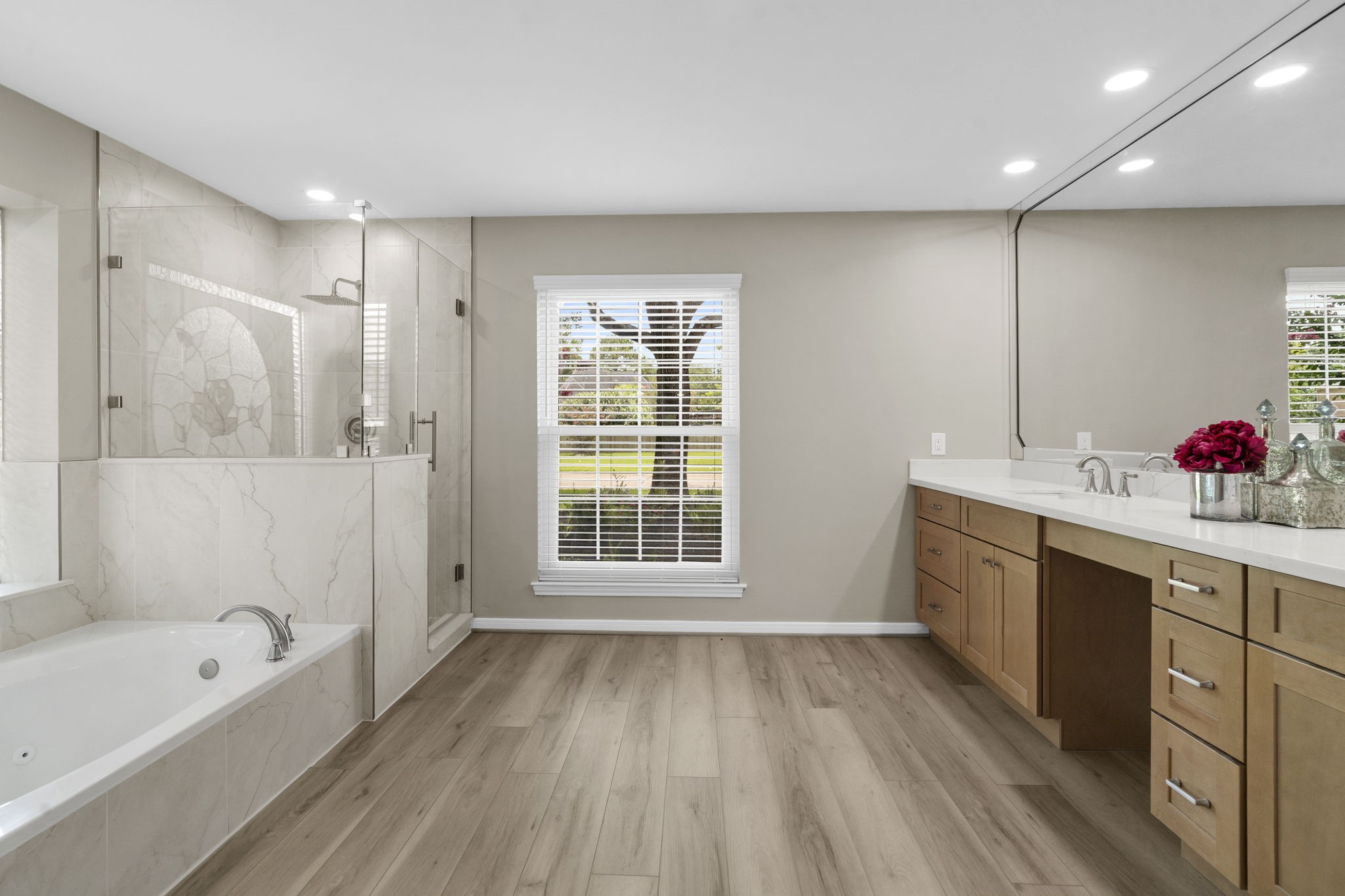 The spa-inspired primary bath continues with a soaking tub, oversized frameless glass shower & beautiful designer tile extending throughout the shower and tub surround. The spa-inspired primary bath continues with a soaking tub, oversized frameless glass shower & beautiful designer tile extending throughout the shower and tub surround.