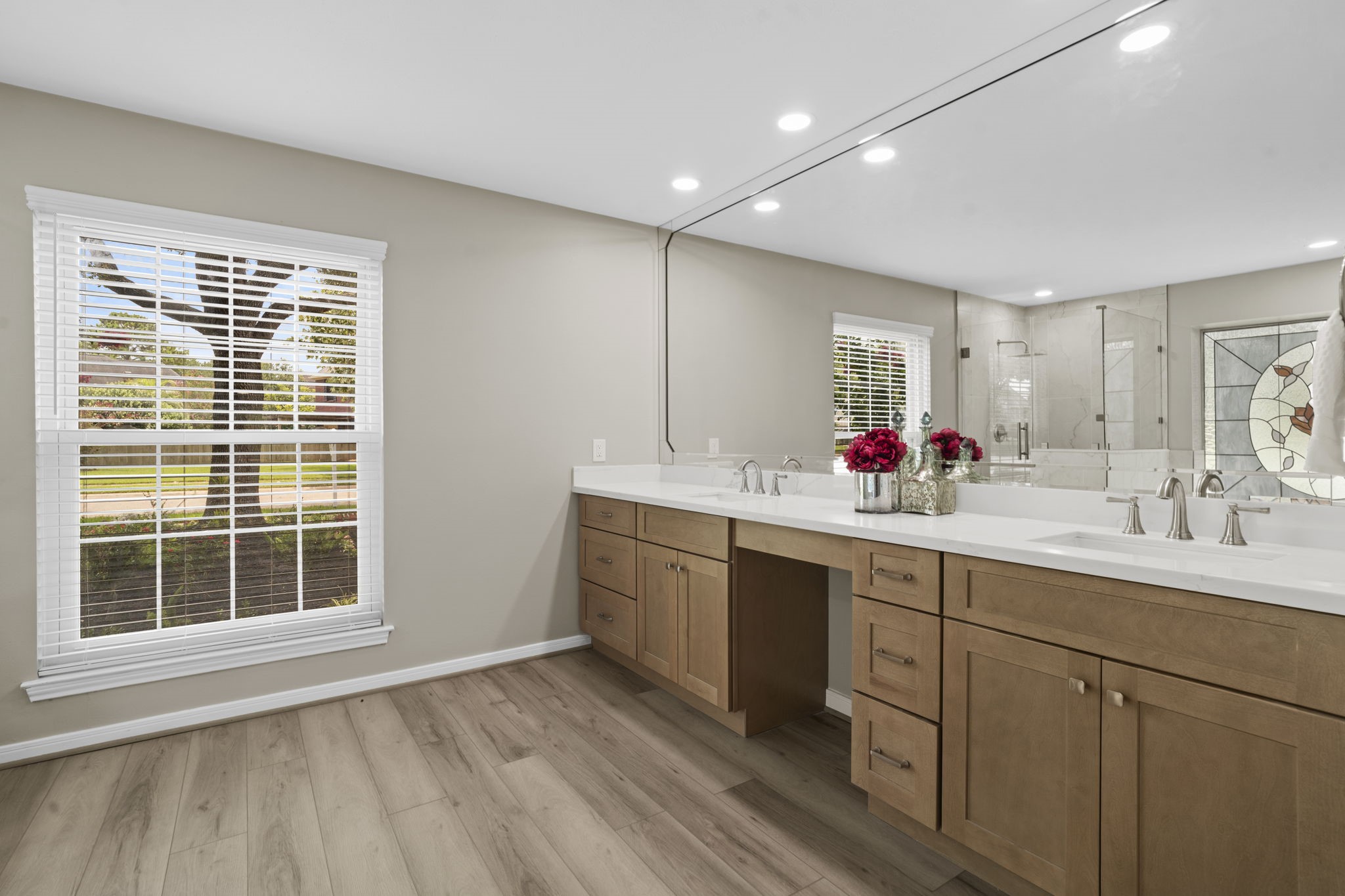 The completely renovated primary bath showcases an expansive custom vanity topped with quartz, dual sinks & an impressive oversized mirror. Thoughtful cabinetry provides abundant storage while maintaining a clean, refined aesthetic. The completely renovated primary bath showcases an expansive custom vanity topped with quartz, dual sinks & an impressive oversized mirror. Thoughtful cabinetry provides abundant storage while maintaining a clean, refined aesthetic.