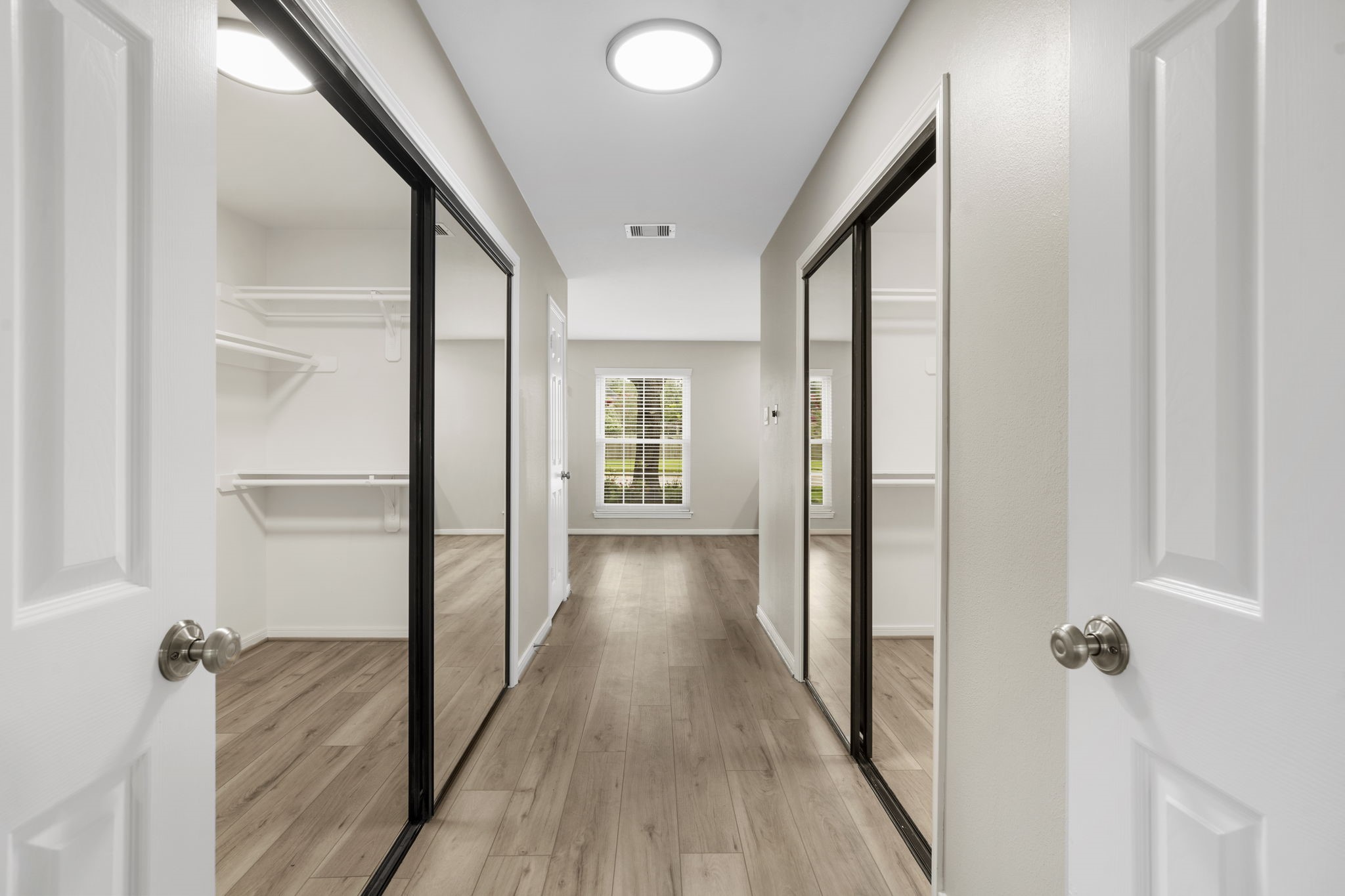 A spacious dressing area connects the primary suite & bath, offering dual closets with mirrored doors and abundant storage on both sides. A spacious dressing area connects the primary suite & bath, offering dual closets with mirrored doors and abundant storage on both sides.