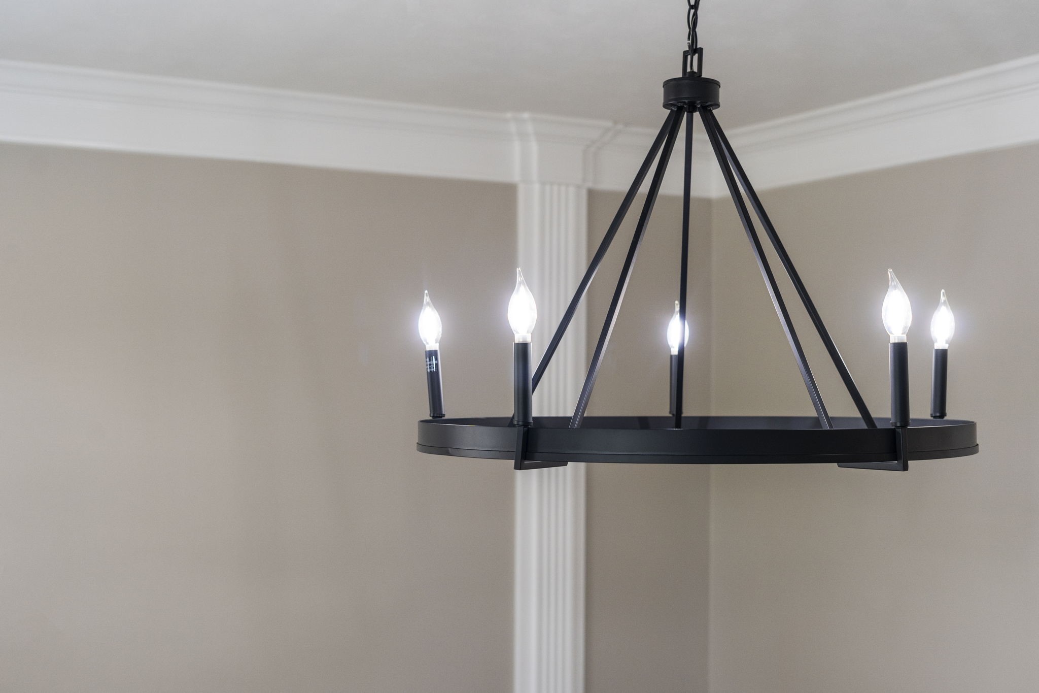 A modern statement chandelier adds a bold designer element, beautifully complemented by the rooms detailed millwork & crown molding.