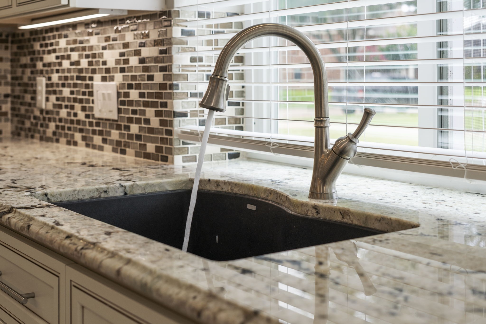A deep undermount sink paired with a pull-down faucet offers everyday functionality.