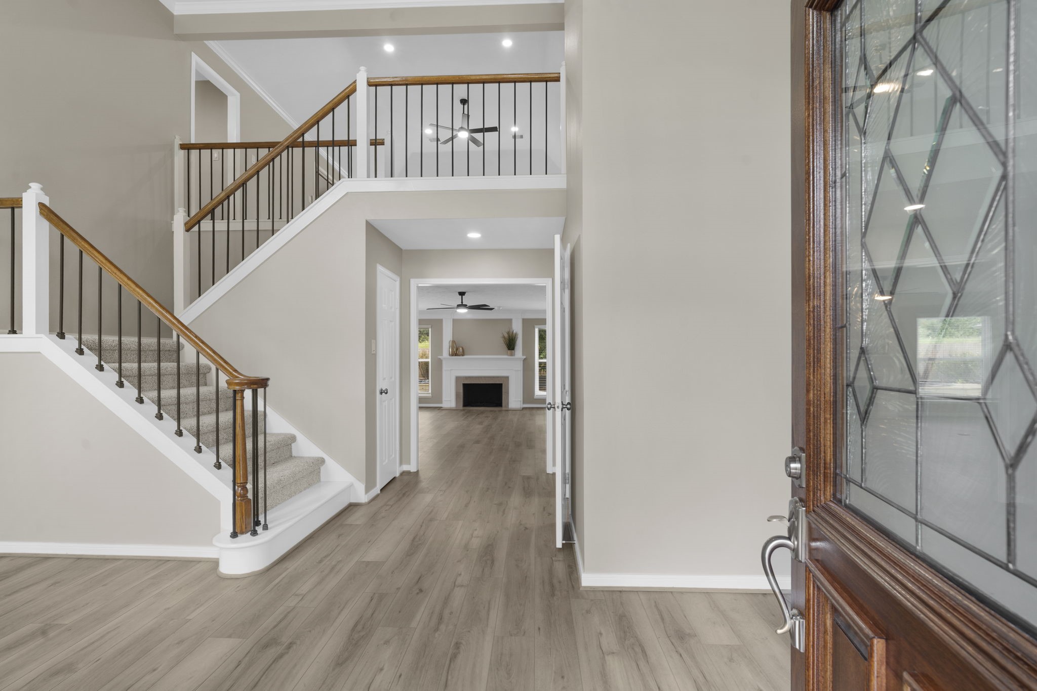Step inside to a bright two-story foyer featuring wrought iron staircase spindles, fresh designer paint & updated flooring. The open sightline draws you through the home toward the family room beyond.