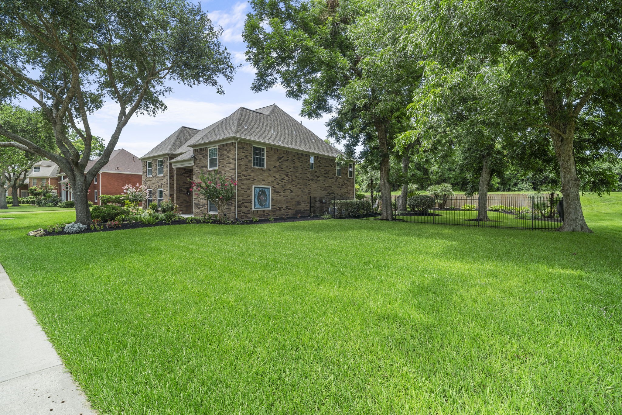 An expansive corner lot offers an impressive amount of green space, framed by mature trees & beautifully maintained landscaping.