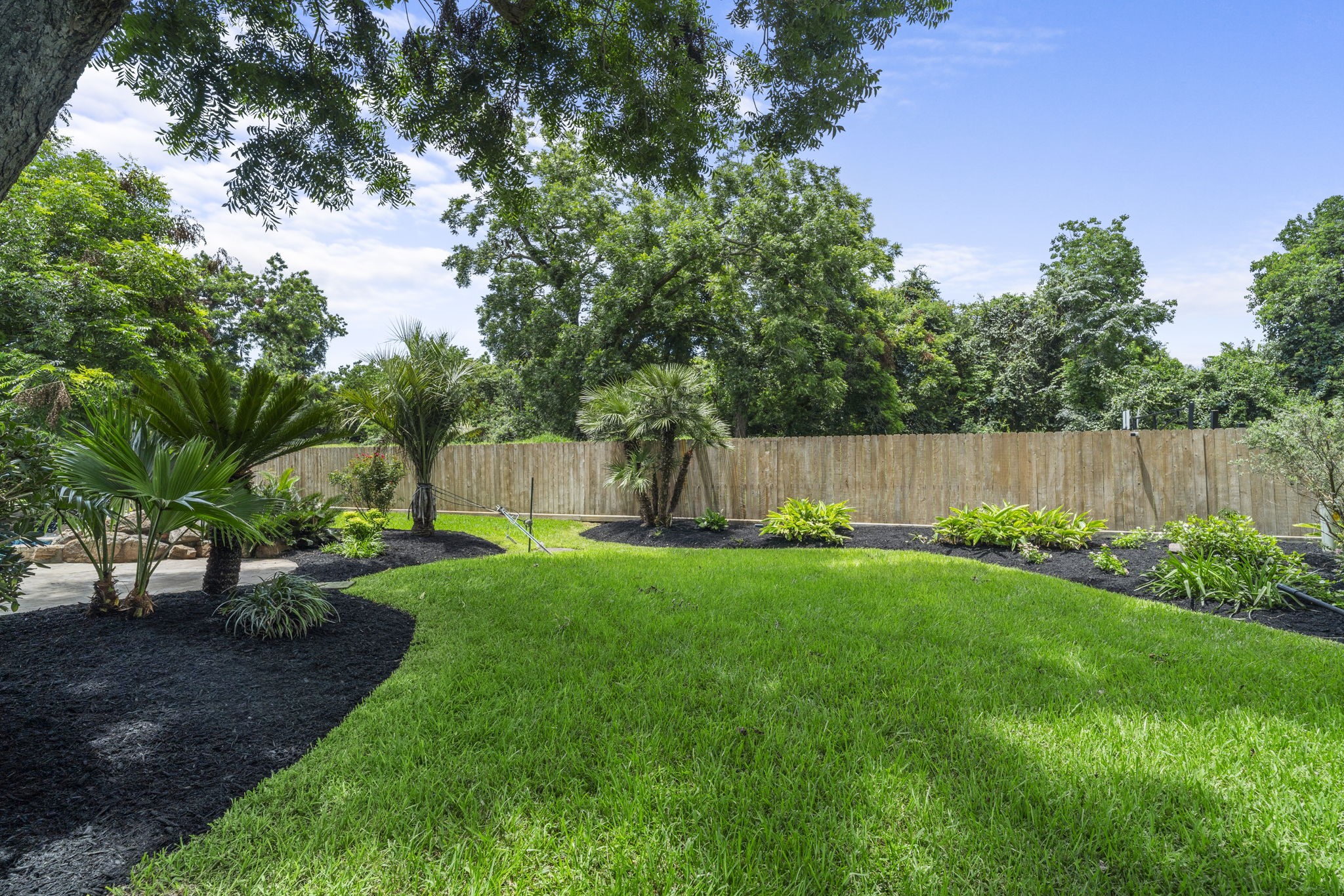 The oversized lot continues with an expansive lawn beyond the pool area, offering plenty of usable yard space while established landscaping adds a polished finish.