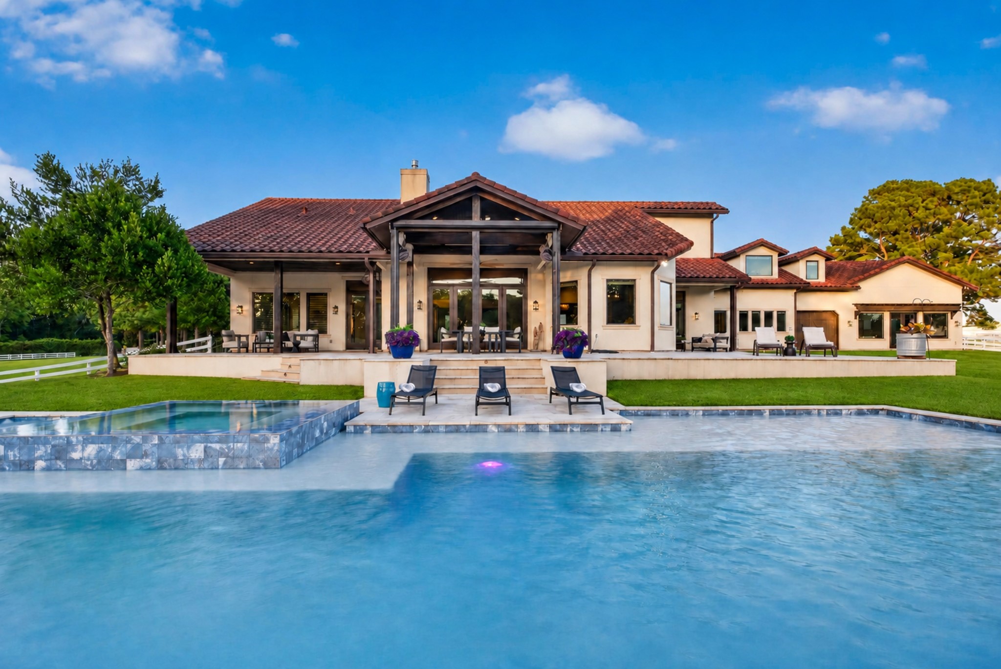 The rear elevation opens gracefully to a poolside terrace designed for effortless entertaining.