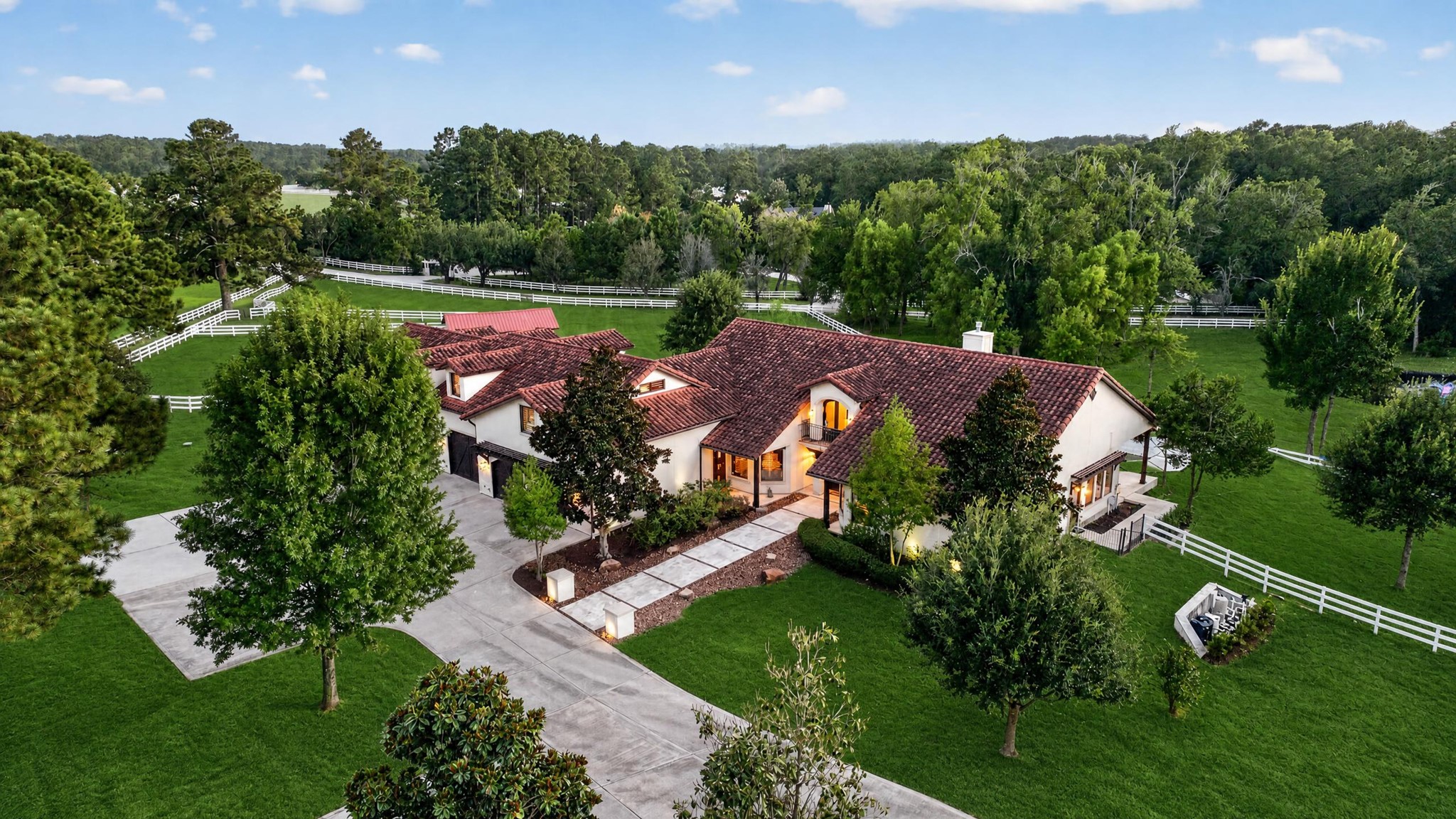 A sweeping circular drive reveals a thoughtfully planned custom home surrounded by mature trees.