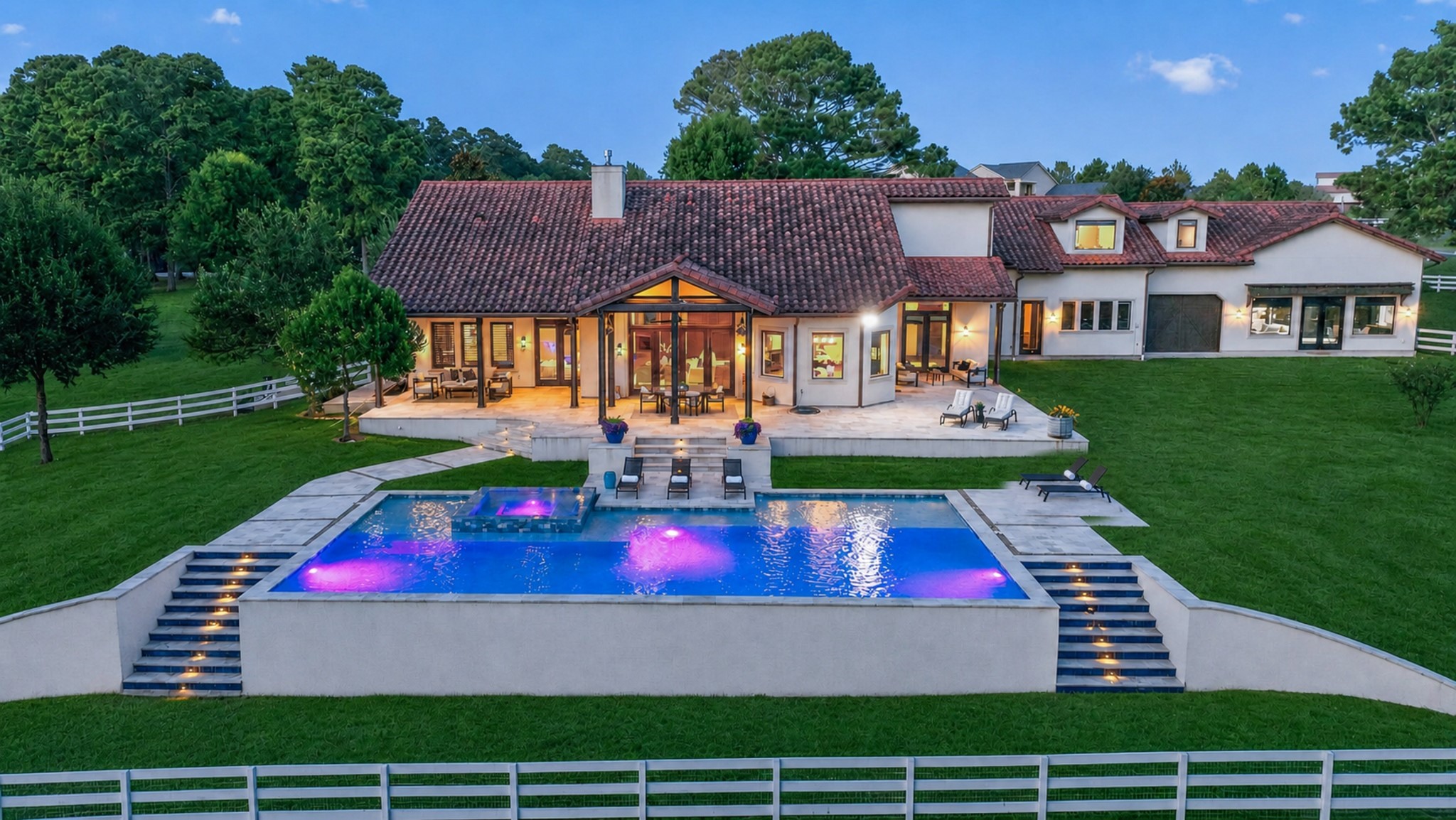 Welcome home where twilight, open land and a glowing pool create a pure escape.