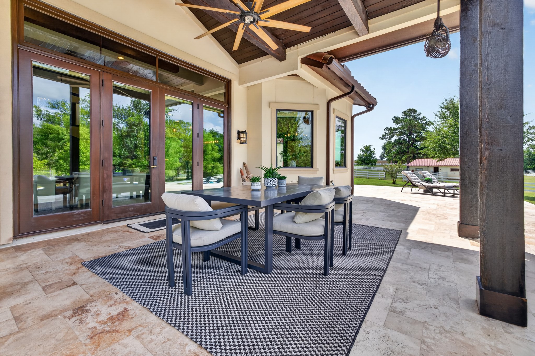 Covered outdoor dining turns family meals into relaxed poolside evenings beneath soaring beams.