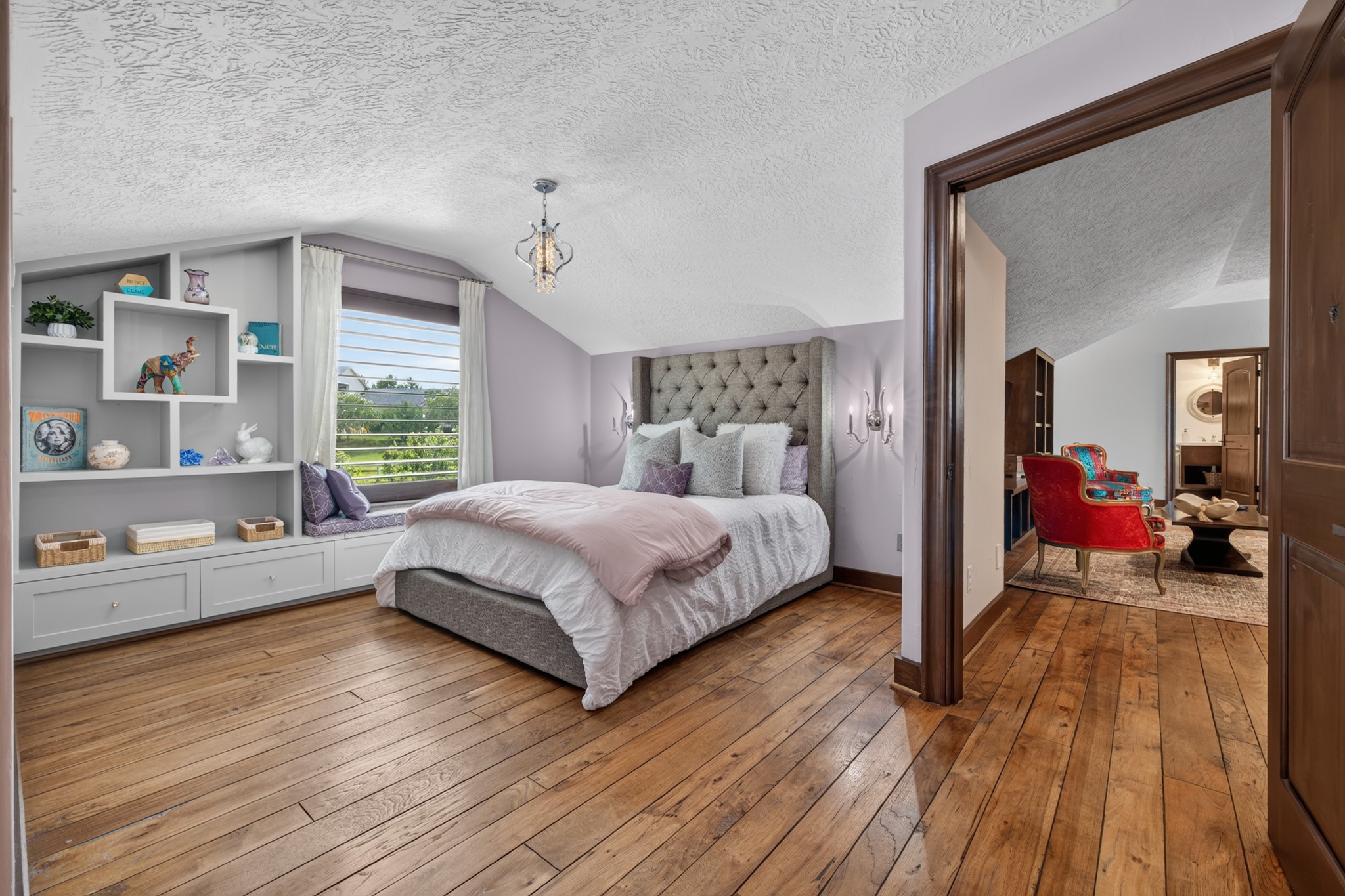 A peaceful secondary bedroom offers built-in storage, natural light and restful countryside views.