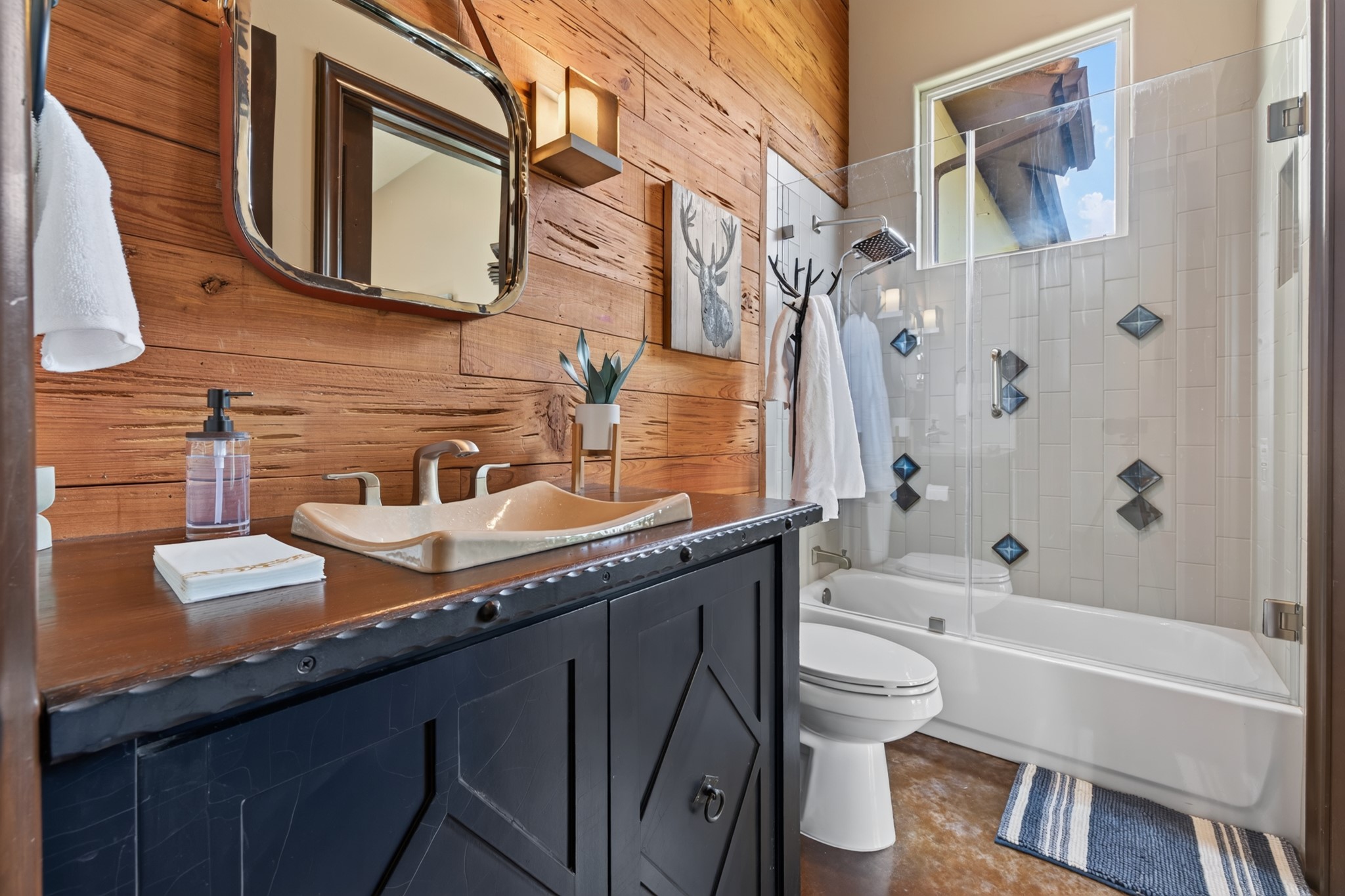 Warm wood accents and rich textures give the secondary bath relaxed, memorable character.
