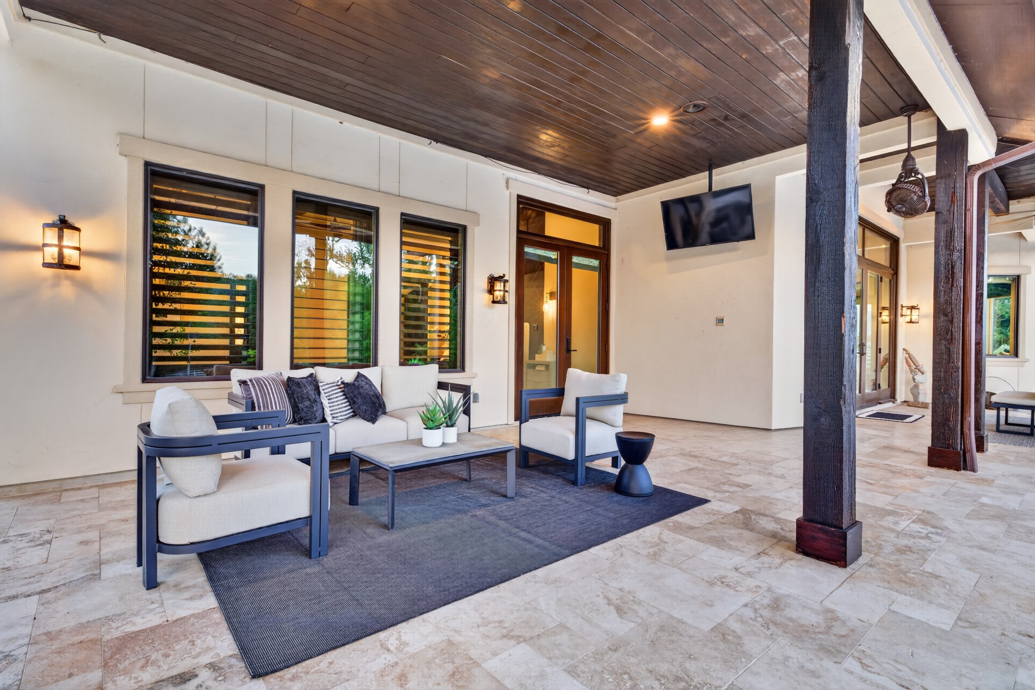 A private covered retreat off the primary suite offers shade, serenity and views across the grounds.