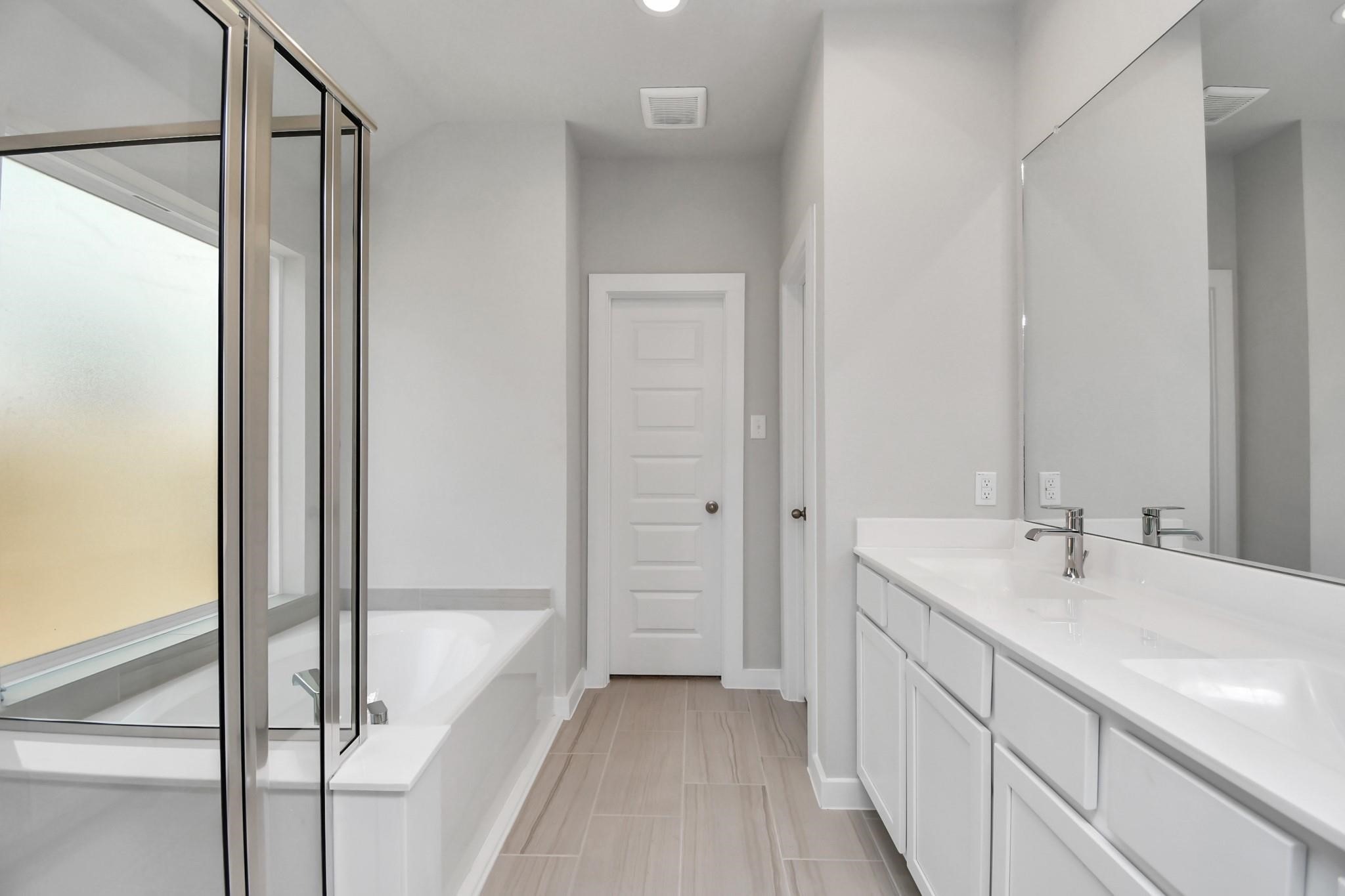 Primary bathroom with his and her sink, separate shower and soaking tub.