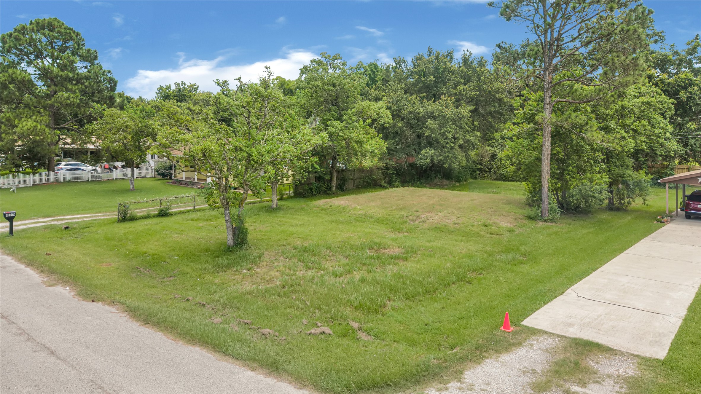 Expansive vacant lot with lush greenery, nestled in a serene neighborhood, offers an ideal setting for building your dream home.