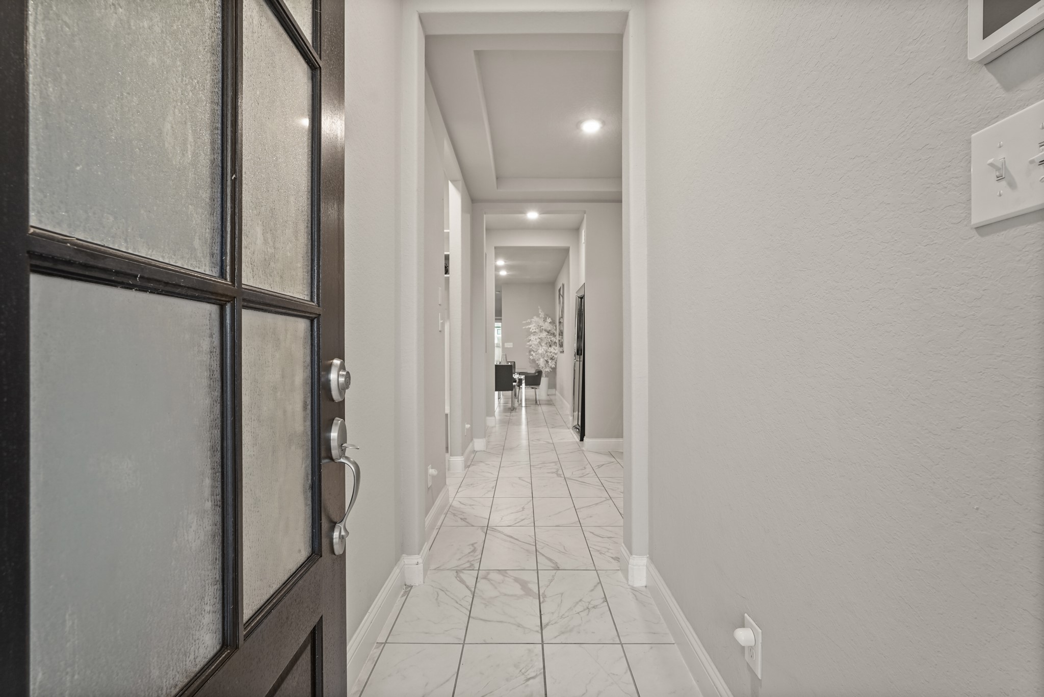 Step inside to a grand first impression with this long, sophisticated foyer. High-gloss, large-format marble-patterned porcelain tile that bounces light and expands the space. Step inside to a grand first impression with this long, sophisticated foyer. High-gloss, large-format marble-patterned porcelain tile that bounces light and expands the space.