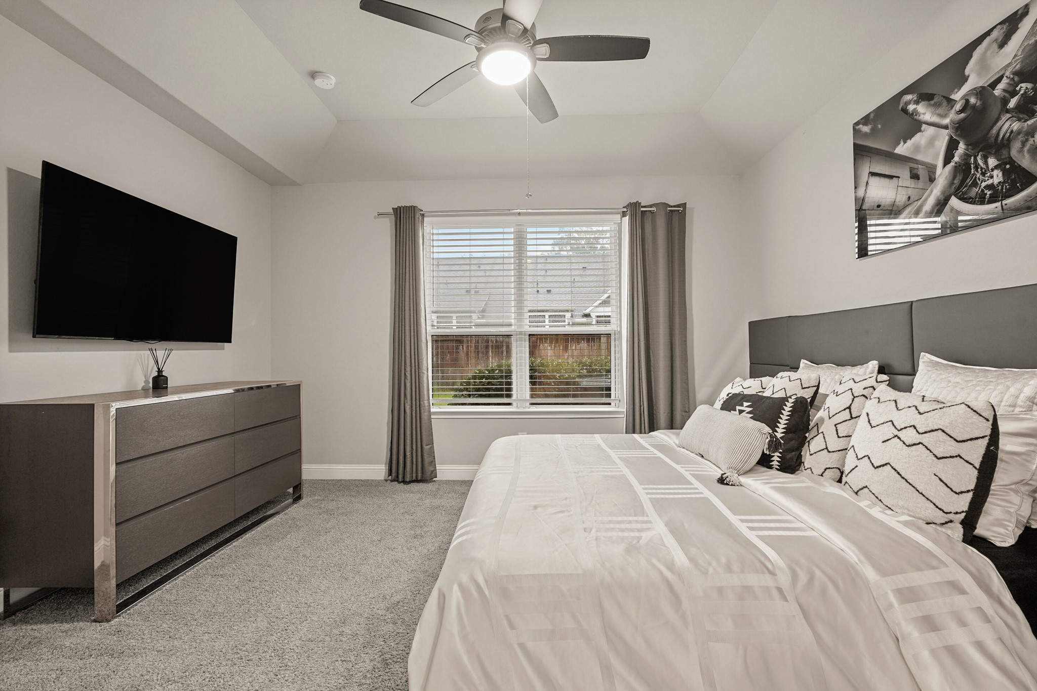 This spacious master bedroom offers a comfortable and modern retreat with a clean, and thoughtful design elements throughout. The room features plush carpeting, soaring ceilings, and a large window that fills the space with natural light while providing views of the backyard. This spacious master bedroom offers a comfortable and modern retreat with a clean, and thoughtful design elements throughout. The room features plush carpeting, soaring ceilings, and a large window that fills the space with natural light while providing views of the backyard.