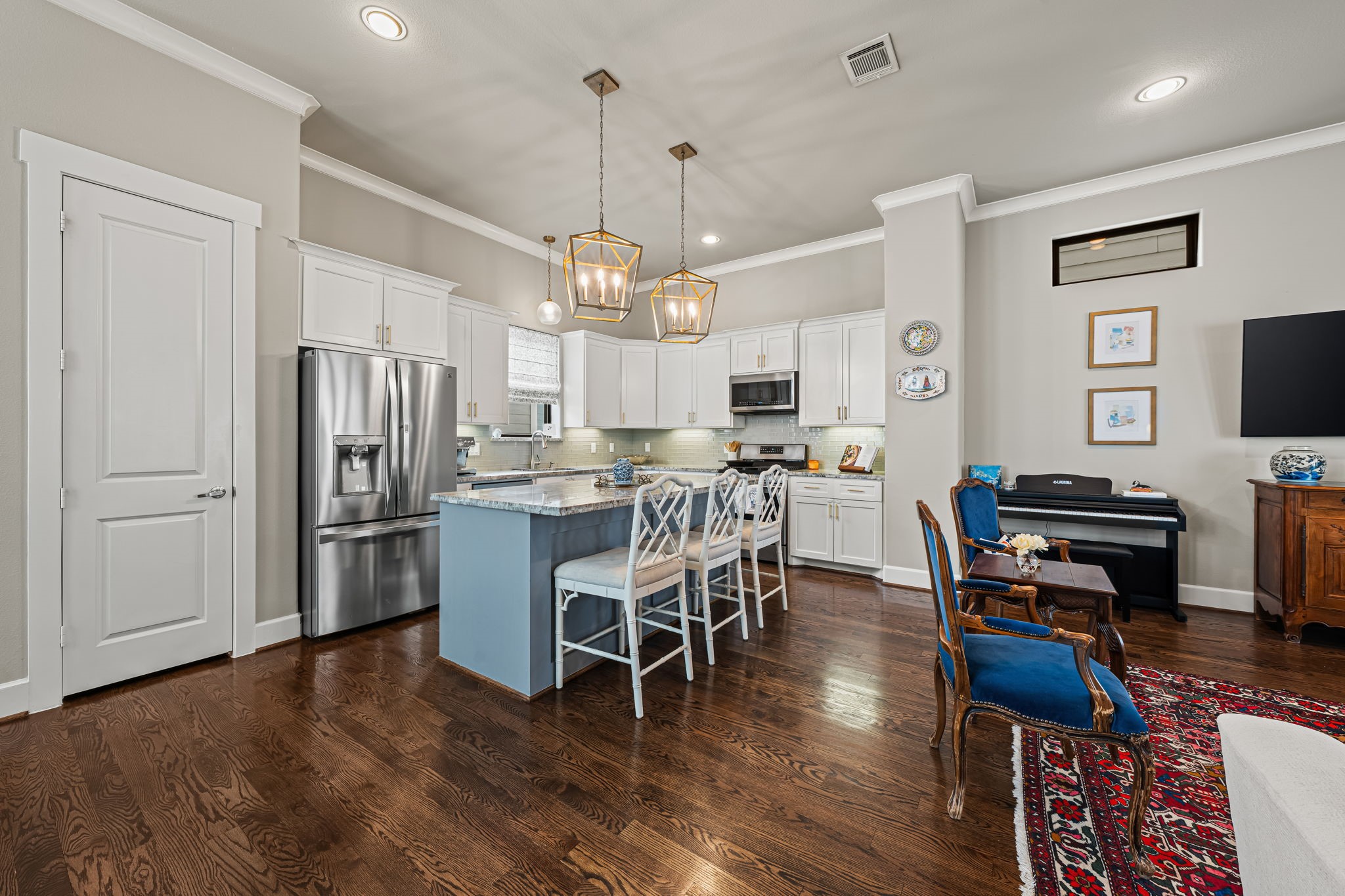 Crisp white cabinetry surrounds a kitchen designed for easy daily routines. The island's extended counter welcomes a quick breakfast or company while dinner comes together.