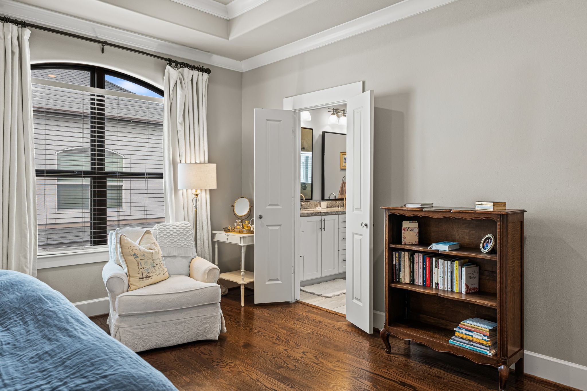 A bright window-side corner offers a peaceful place to begin or end the day in the primary bedroom. The adjoining bathroom keeps the retreat's comforts close at hand.