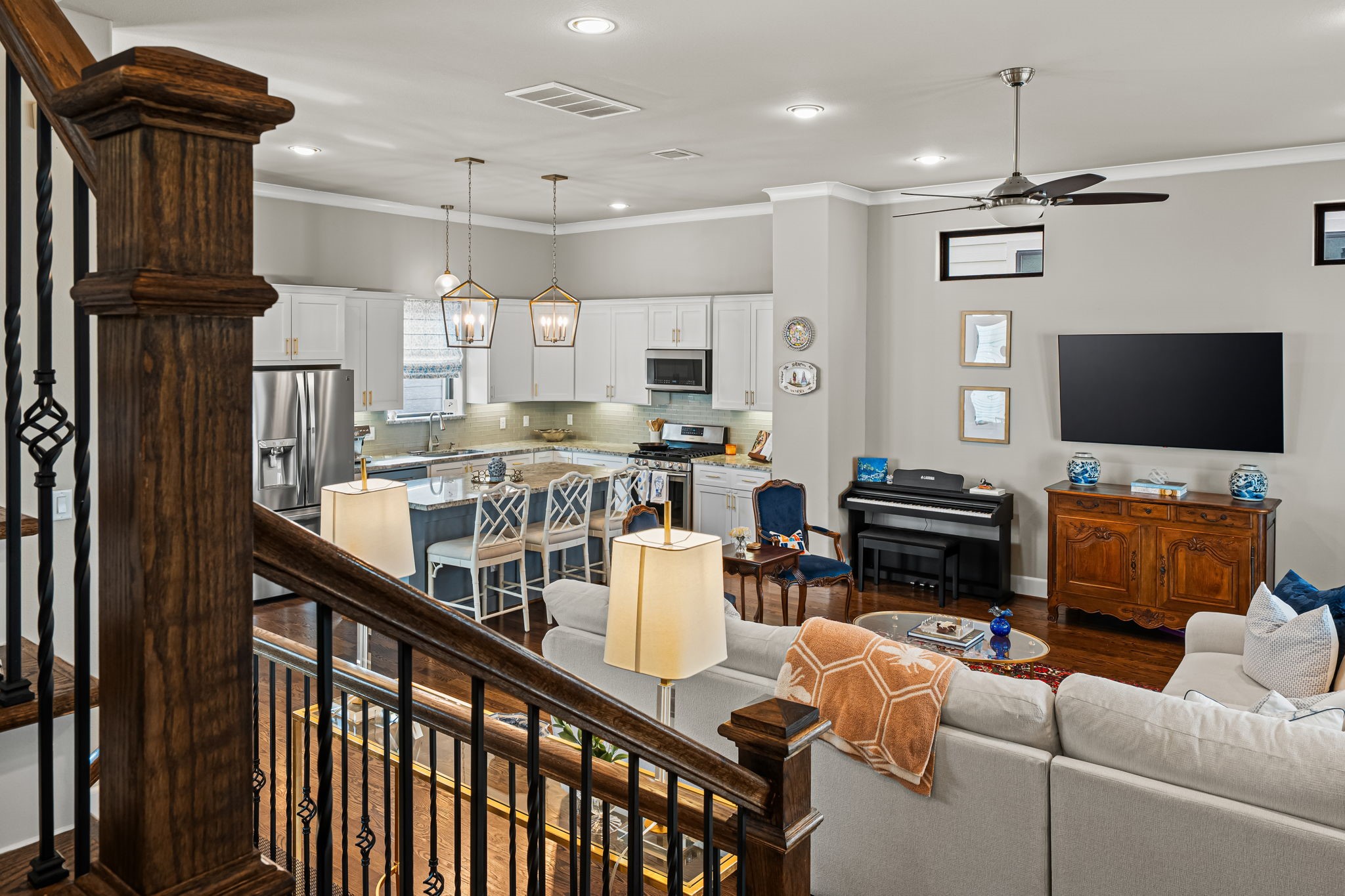 A broad view across the gathering spaces reveals the home's easy, connected layout. Wood and iron detailing provide a graceful border while leaving the kitchen and living area comfortably in view.