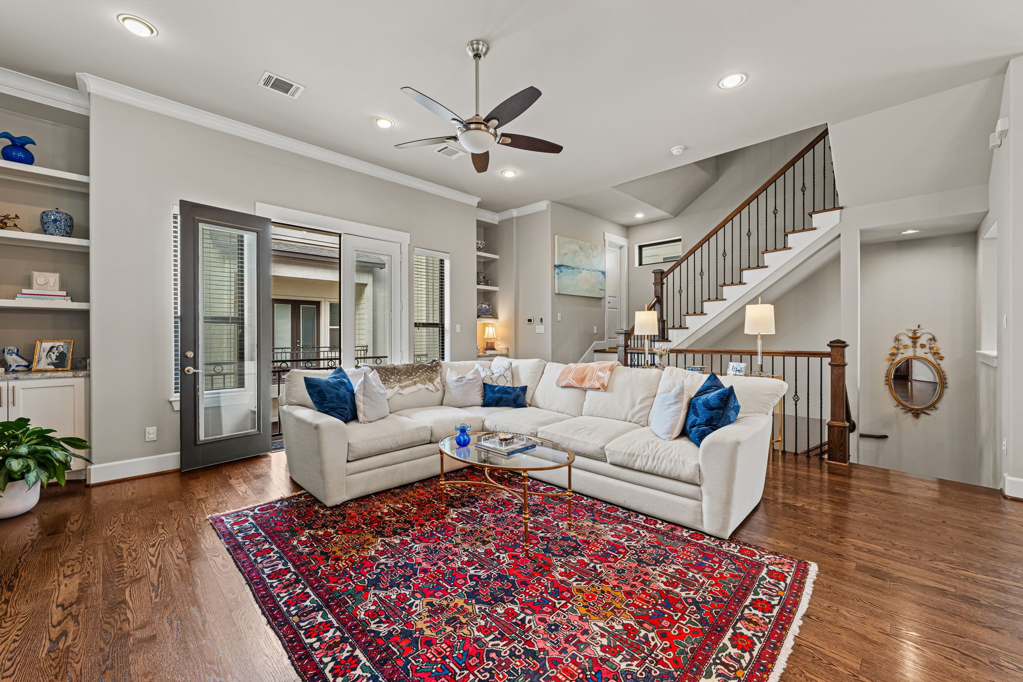 Crown molding outlines the living room with a graceful finishing touch. Warm hardwoods and uninterrupted circulation create an inviting setting for both lively gatherings and slower evenings.