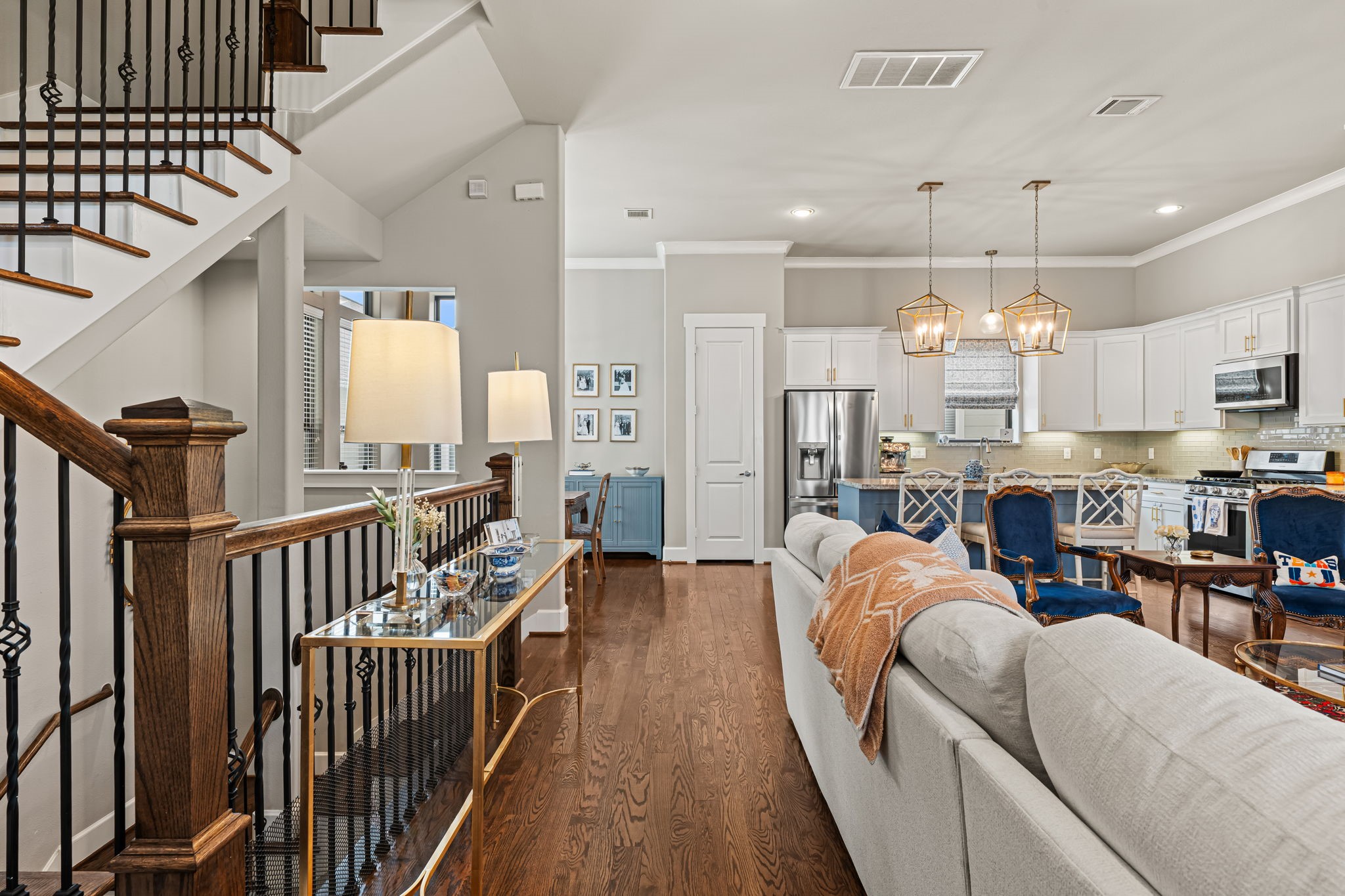 Decorative ironwork and a polished wood handrail lend the living area's edge a touch of craftsmanship. Beyond the railing, the open plan maintains a relaxed connection between daily routines and time together.