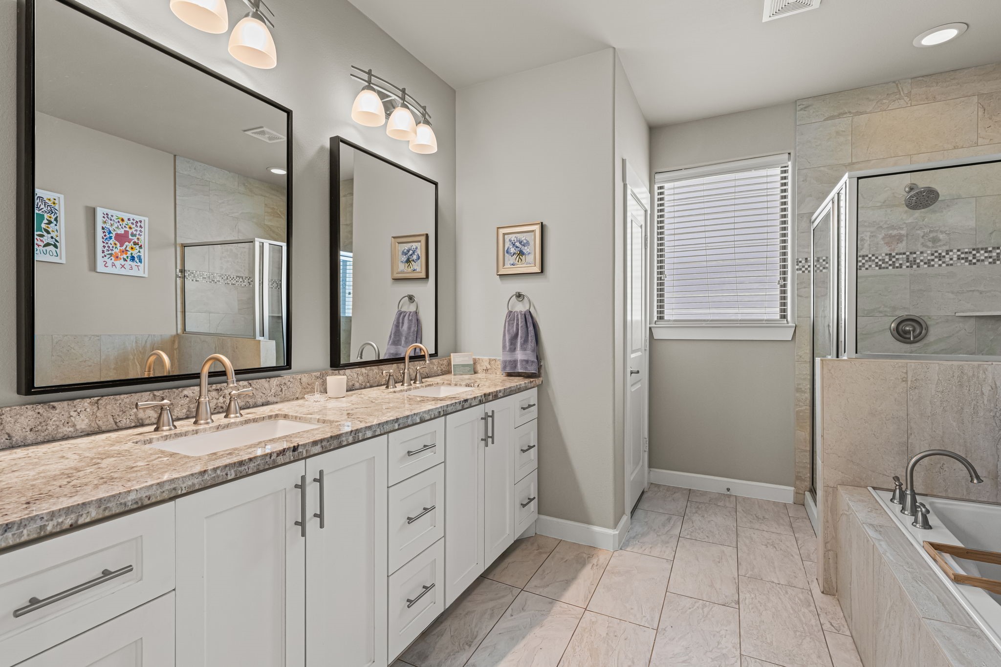 A soaking tub and separate glass-enclosed shower invite an unhurried daily ritual in the primary bath. A long double vanity provides ample space for two to prepare with ease.
