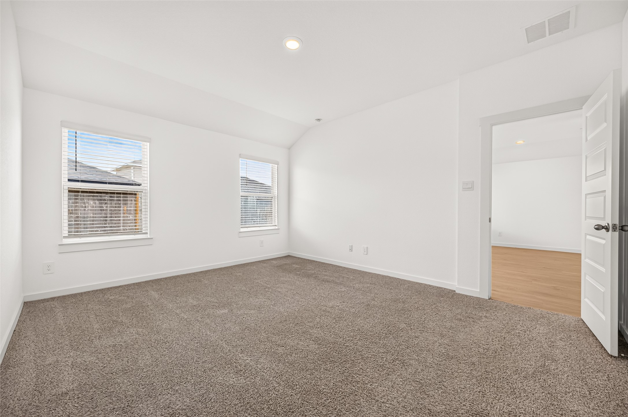 The primary bedroom sits in the back of the home for privacy. Raised ceiling, recessed lighting and mini blinds.
