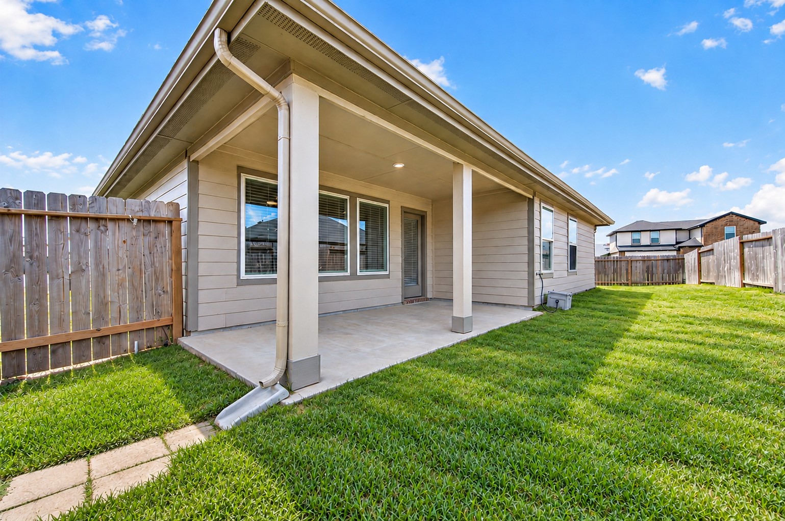 Covered patio in the backyard. The yard extends around the side of the home. Perfect for kiddos and pets.