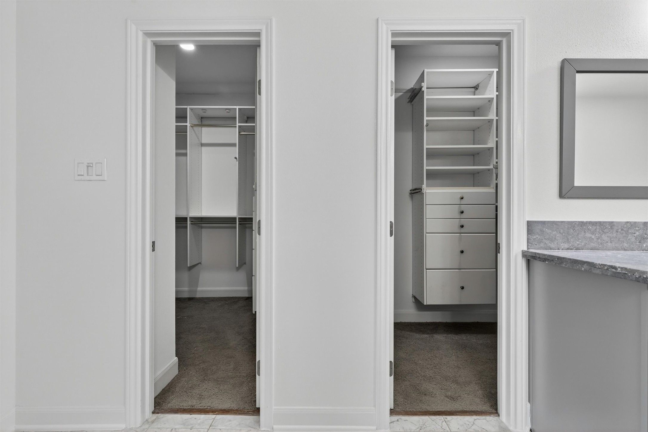 Dual custom walk-in closets with built-in shelving, drawers, and ample storage space provide exceptional organization in the luxurious primary suite. Thoughtfully designed closet systems offer both functionality and style, creating the perfect owners retreat buyers are searching for.