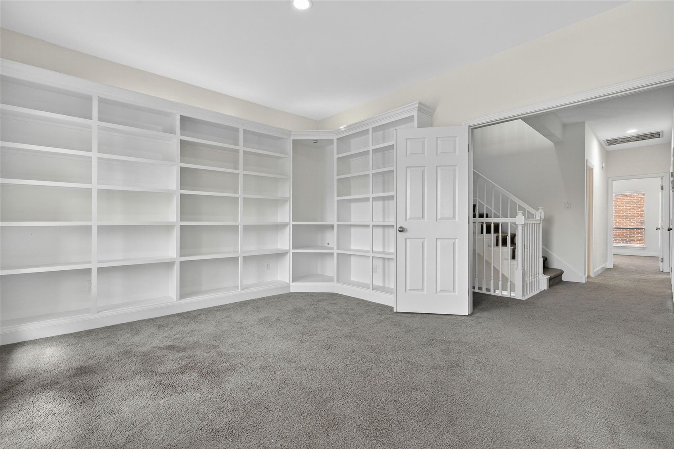 Versatile upstairs flex space featuring custom built-in bookshelves, plush carpet, and abundant storage/display space. Perfect for a home office, library, media room, study area, or game room. Bright neutral finishes and open layout provide endless possibilities for todays lifestyle needs.