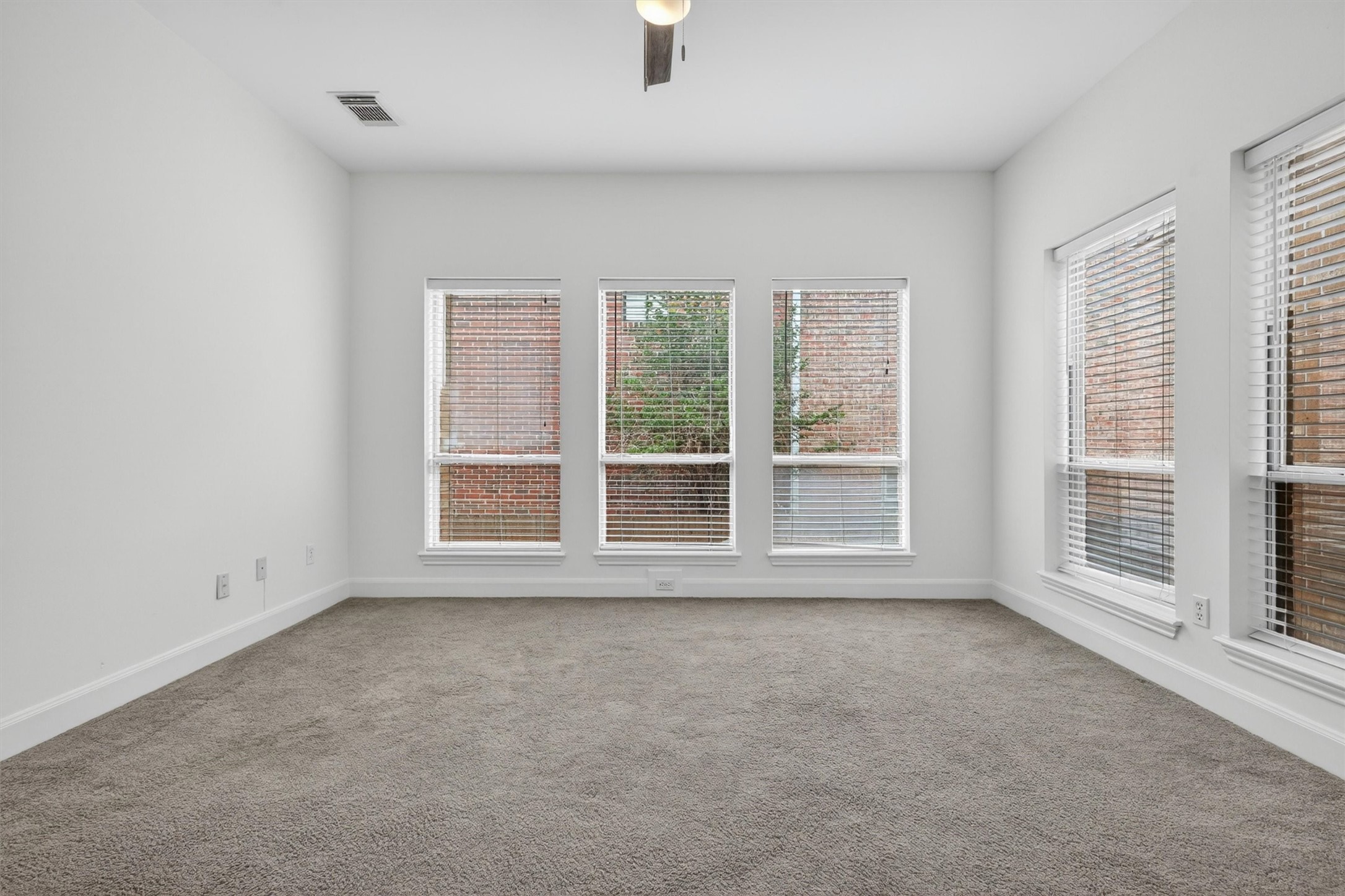 Large secondary bedroom with generous natural light and neutral finishes.