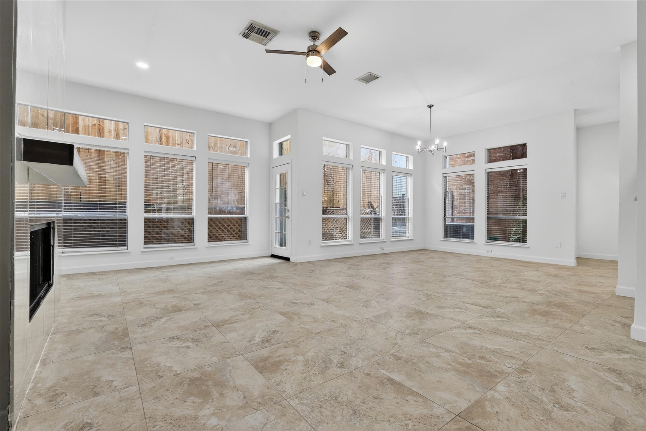 Spacious open-concept living area featuring designer lighting and porcelain fireplace feature wall. Spacious open-concept living area featuring designer lighting and porcelain fireplace feature wall.