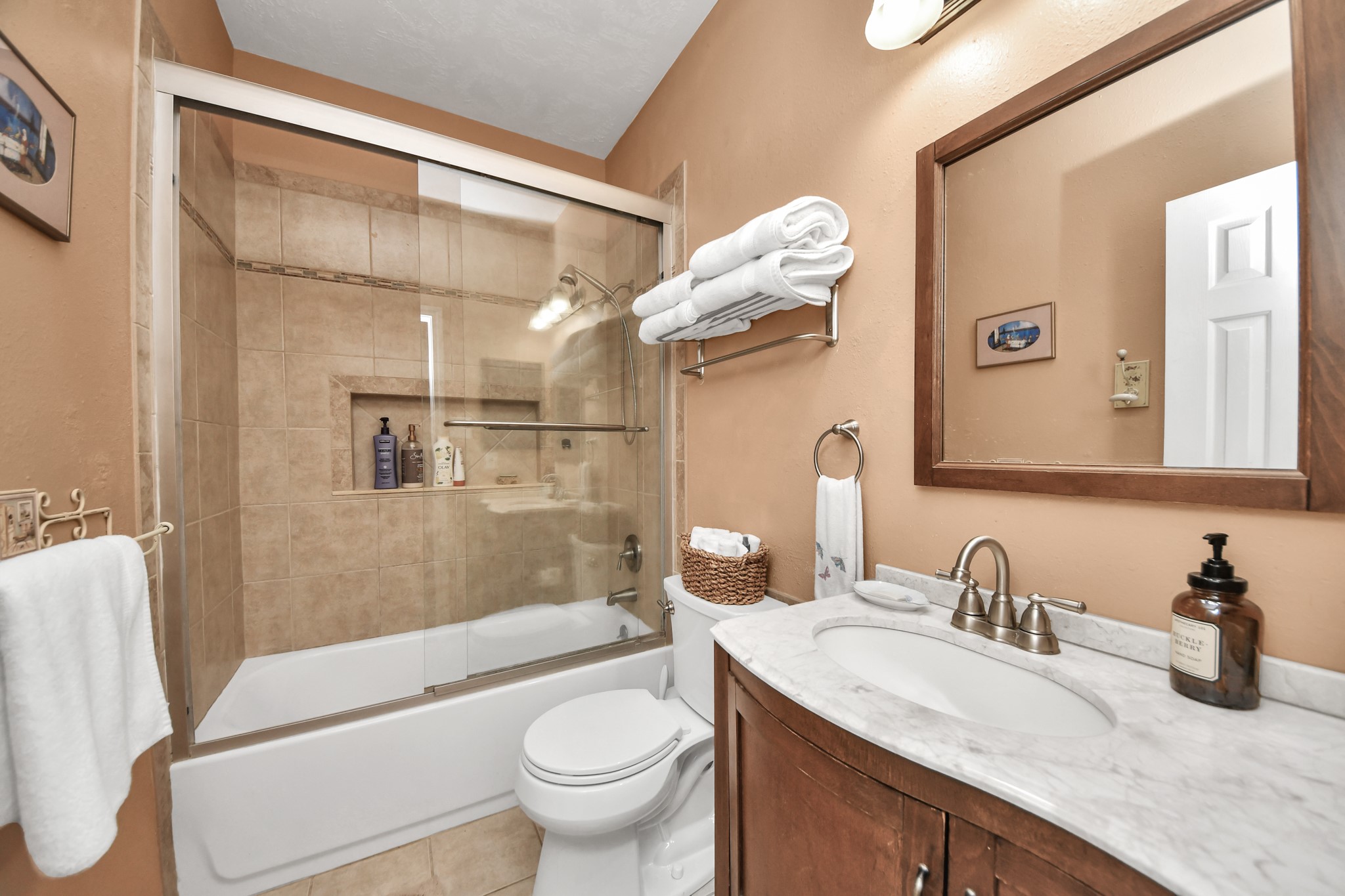 Full secondary bathroom with a tiled tub and shower combination.