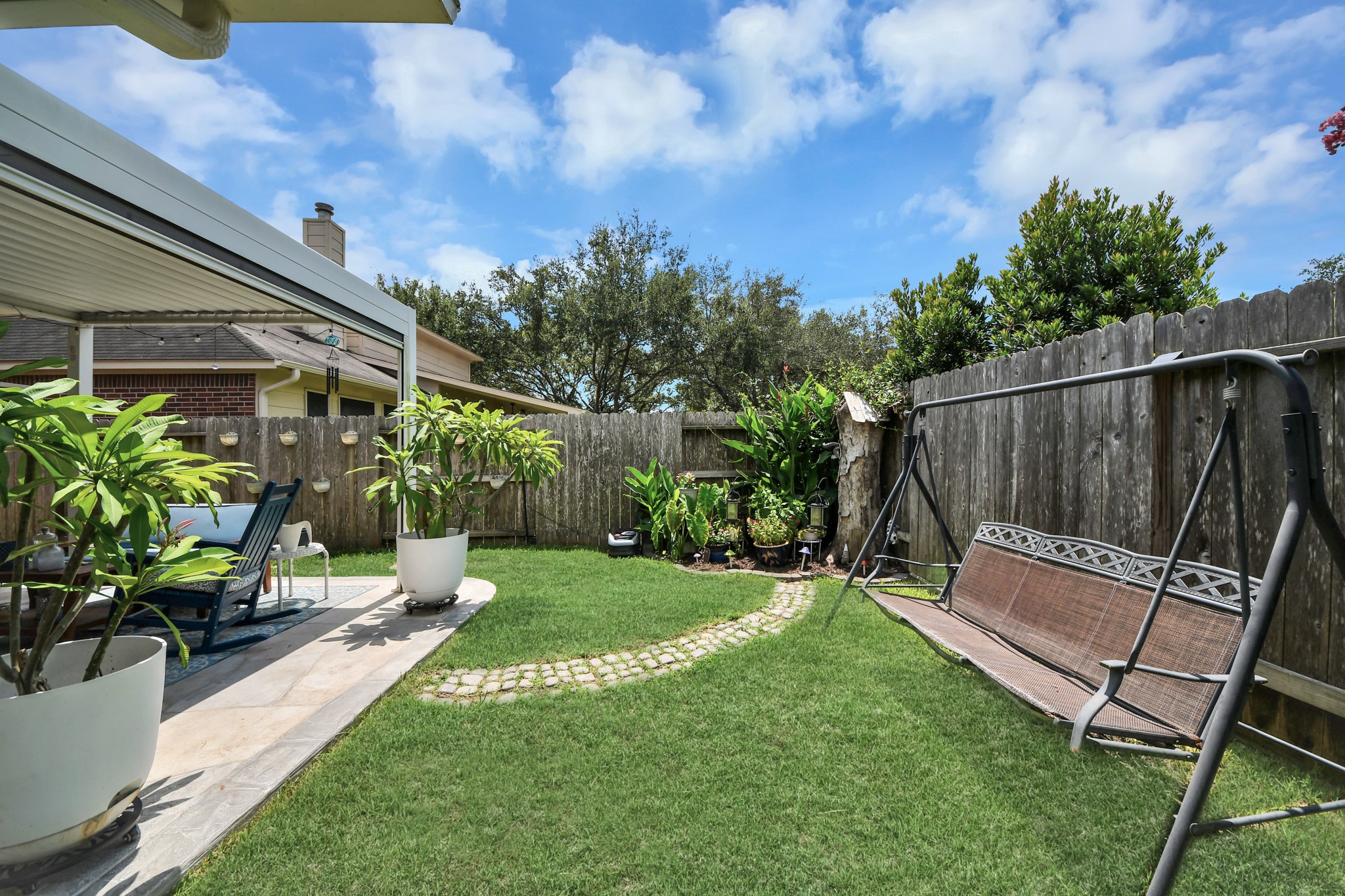 Fully fenced backyard offering green space for recreation, gardening, or pets.